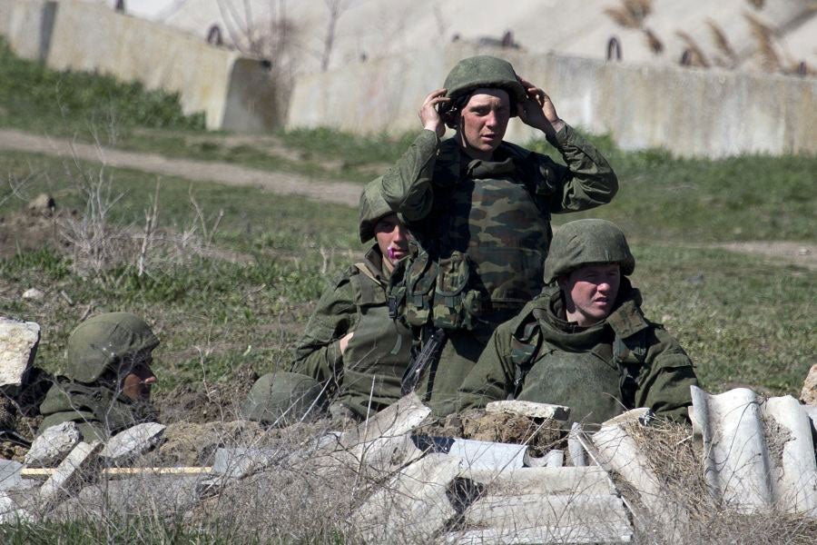 Pro- Russian soldiers in unmarked uniforms arrange a position near Ukrainian marines base in the city of Feodosia