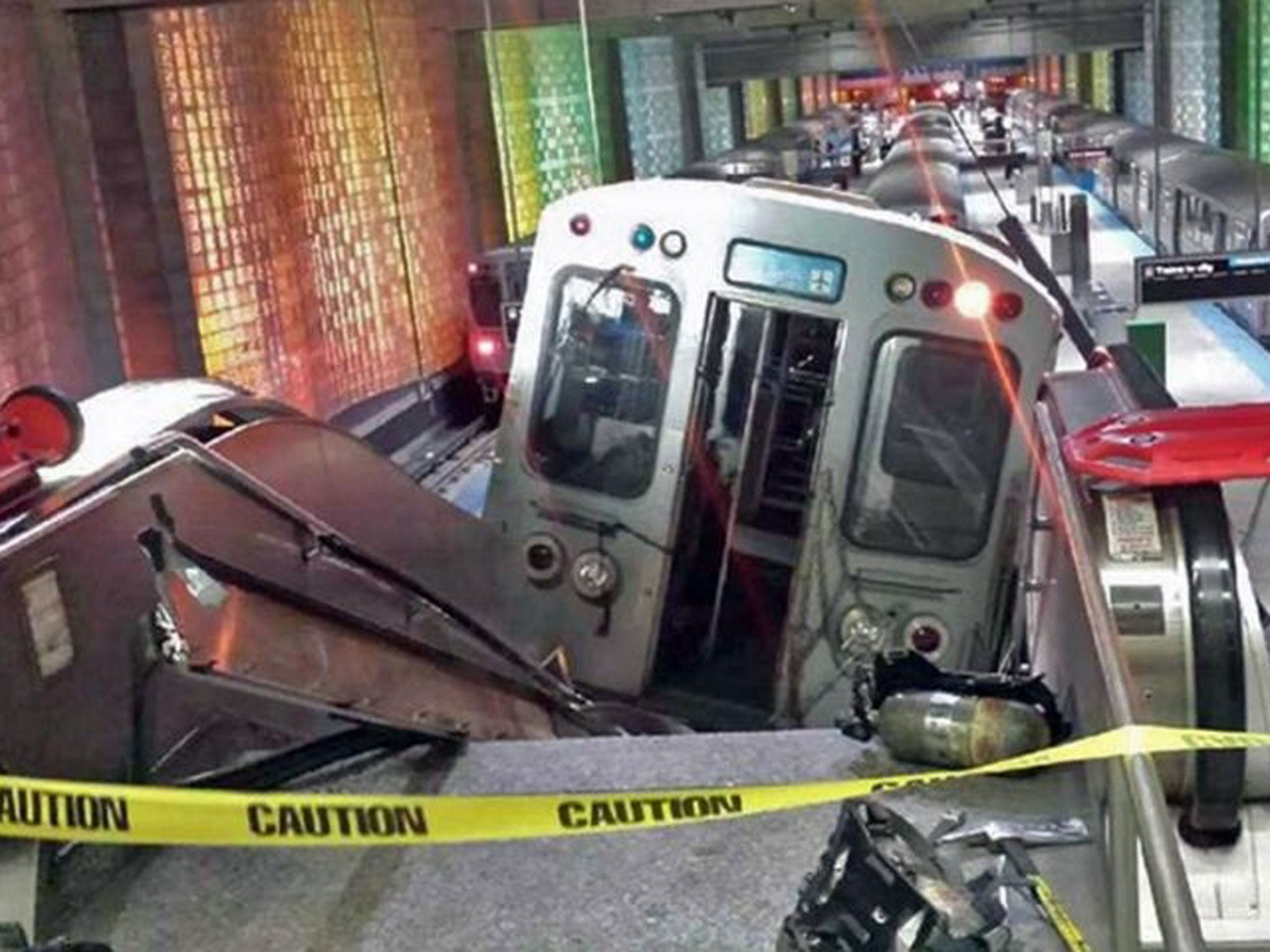 A Chicago Transit Authority train car rests on an escalator at the O'Hare Airport station after it derailed early Monday, March 24, 2014, in Chicago. More than 30 people were injured after the train "climbed over the last stop, jumped up on the sidewalk a