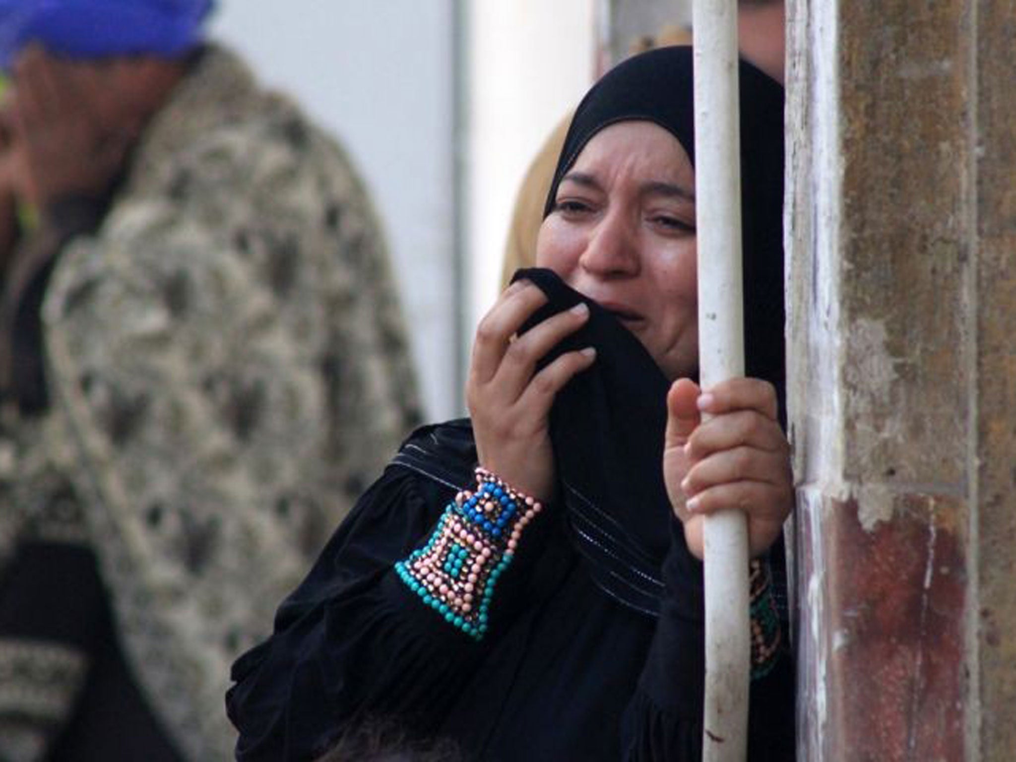 A relative of a supporter of Egyptian ousted Islamist president Mohamed Morsi cries outside the courthouse ]