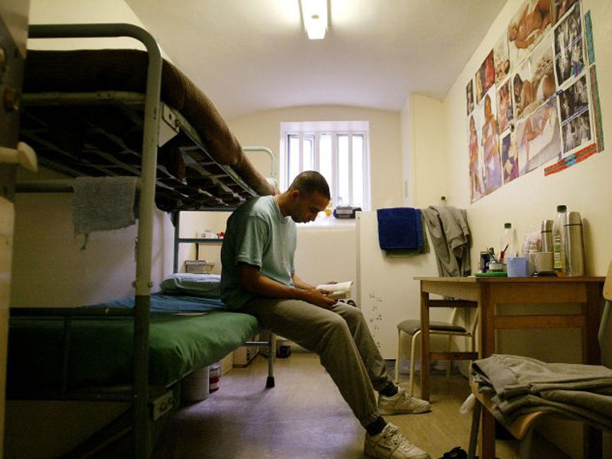 A prisoner reads a book in his cell at HMP (Her Majesty's Prison) Pentonville