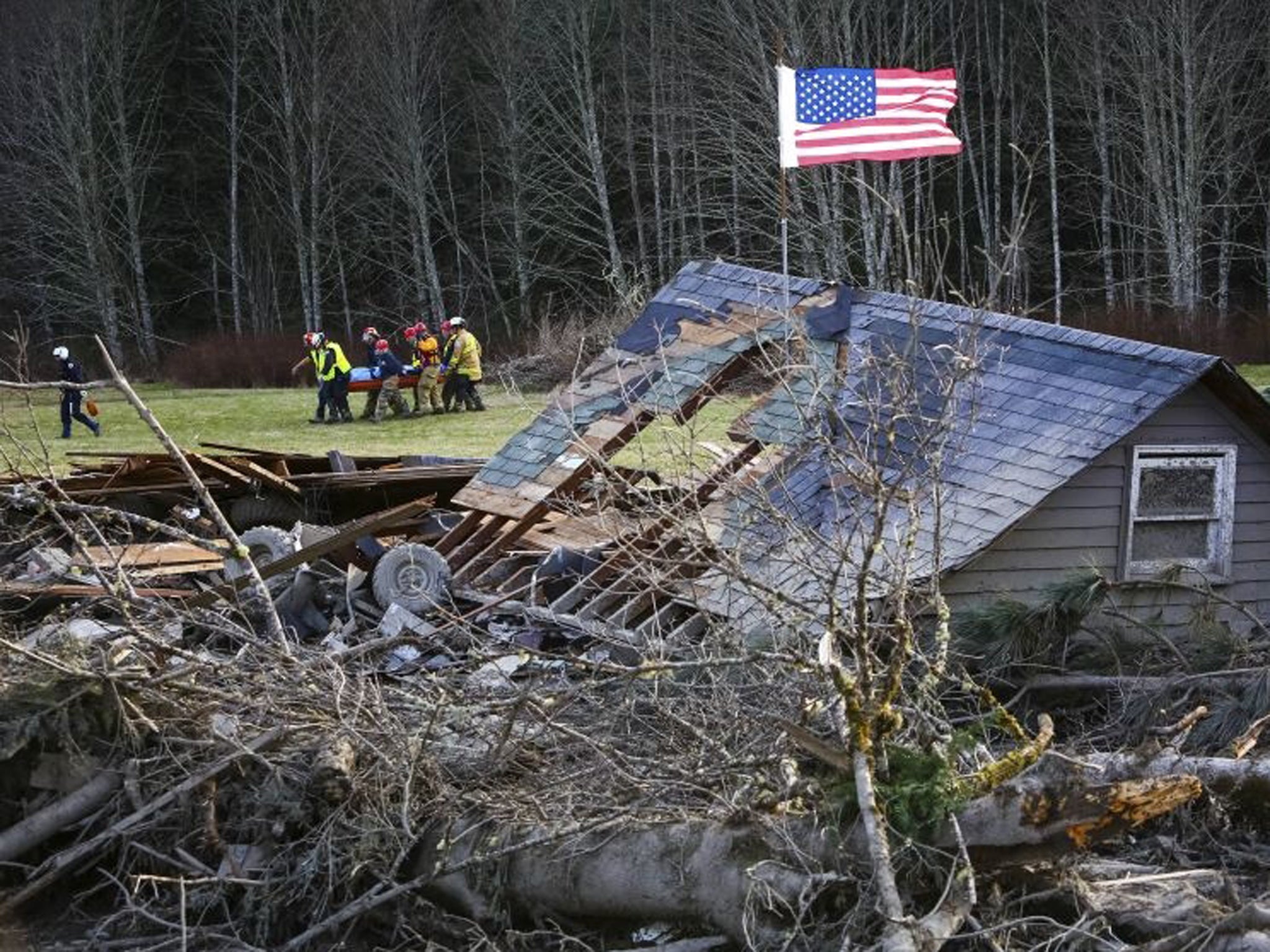 Rescue workers remove a body from the wreckage of homes destroyed by a mudslide near Oso