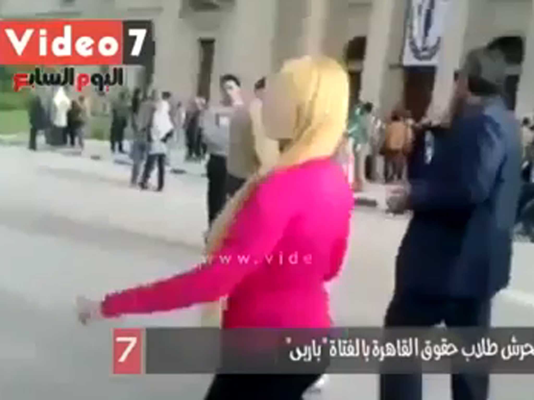 The woman was quickly surrounded by men as she walked through Cairo University campus