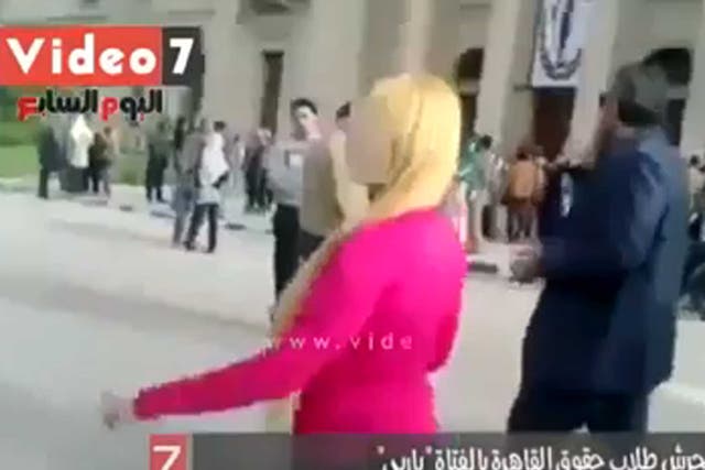 The woman was quickly surrounded by men as she walked through Cairo University campus