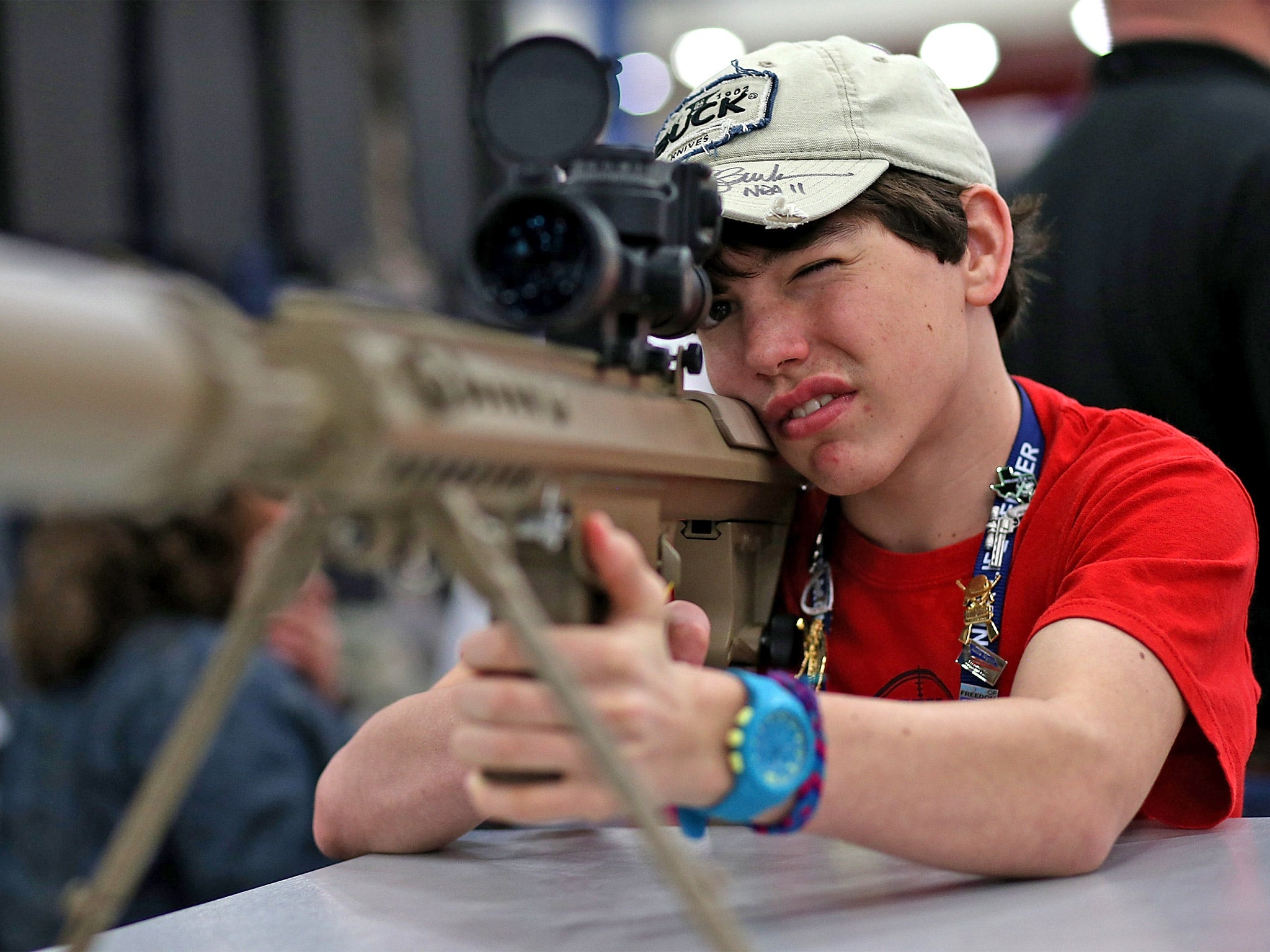 A young boy inspects a high-power sniper rifle at the 2013 NRA annual show