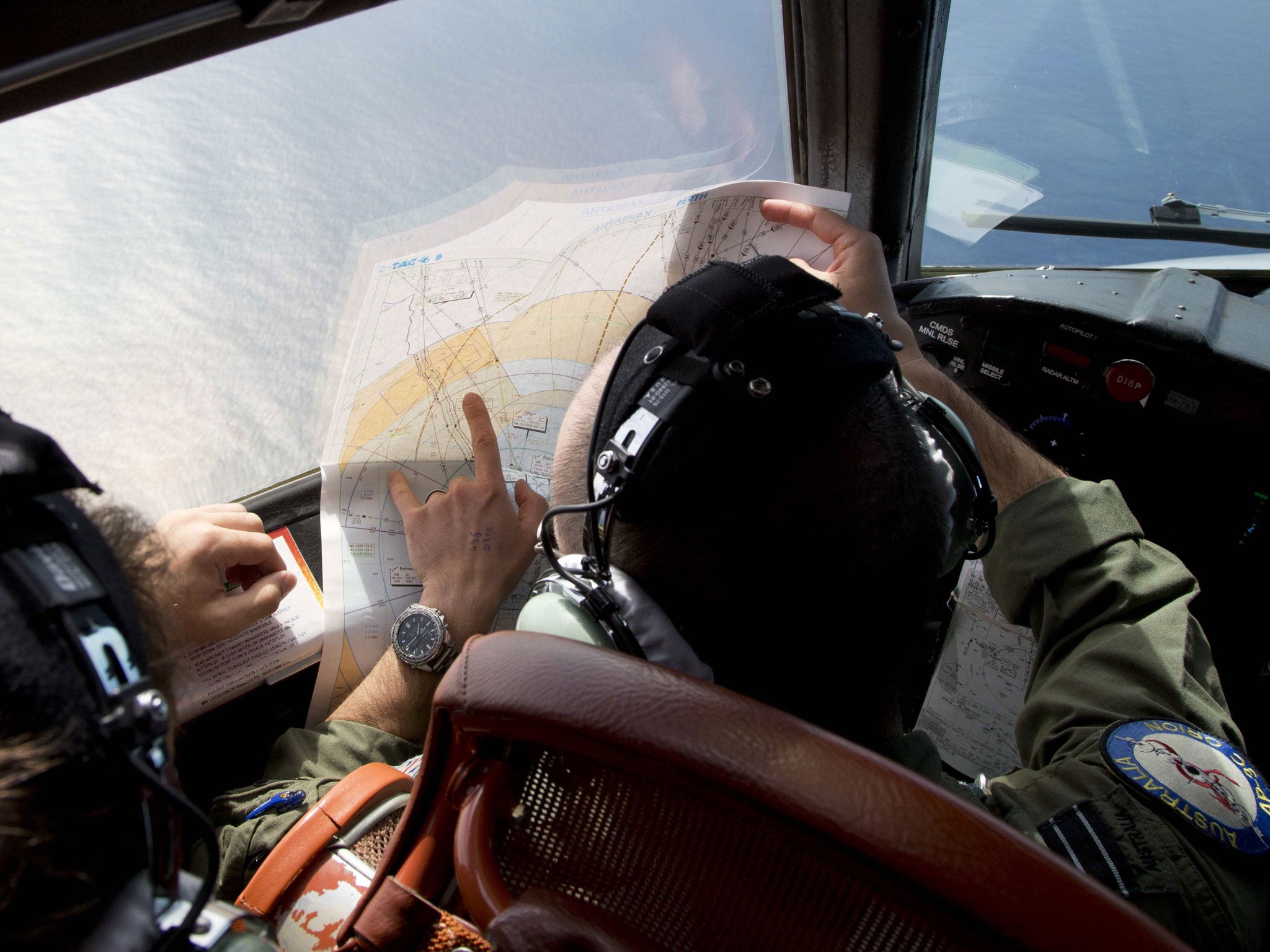 Flight Lieutenant Jayson Nichols looks at a map as he flies aboard a Royal Australian Air Force AP-3C Orion aircraft searching for missing Malaysian Airlines flight MH370 over the southern Indian Ocean