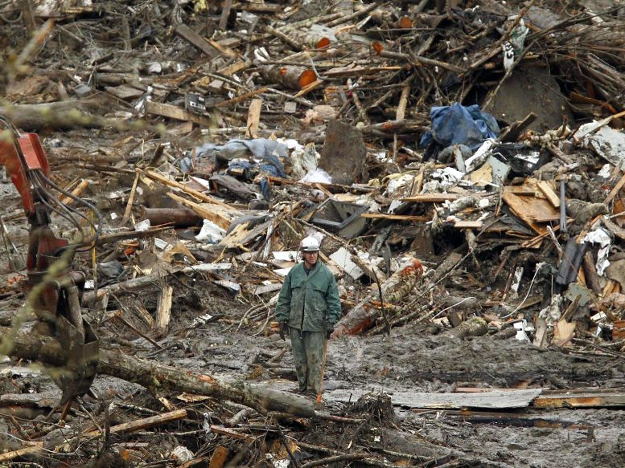 A rescue worker looks over the debris pile from the mudslide in Oso, Washington March 27, 2014.