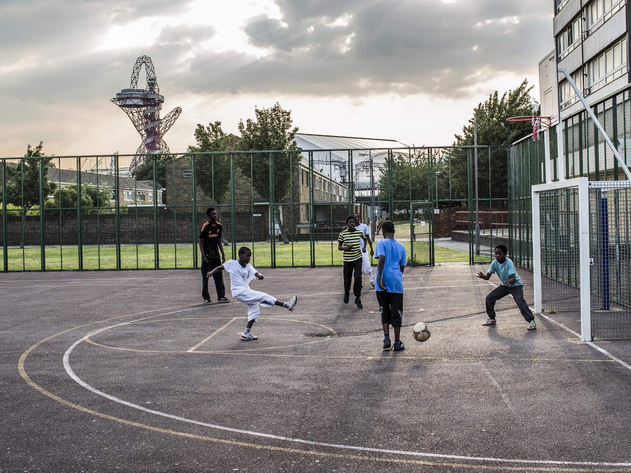 Children play at a community park in east London but spending on pitches has been cut