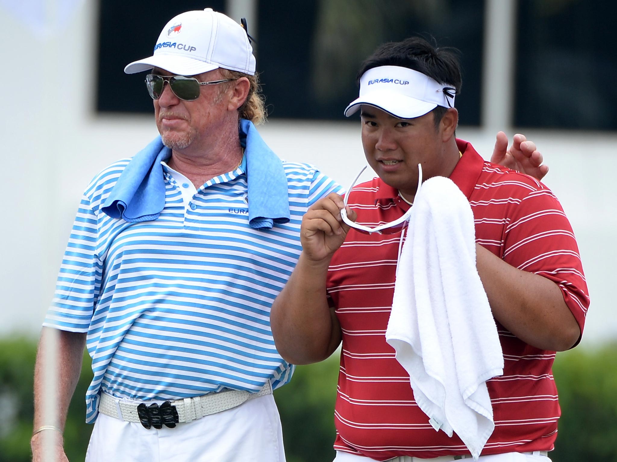 Miguel Angel Jimenez the captain of Team Europe and Kiradech Aphibarnrat of Team Asia during the foursome matches on day two of the EurAsia Cup