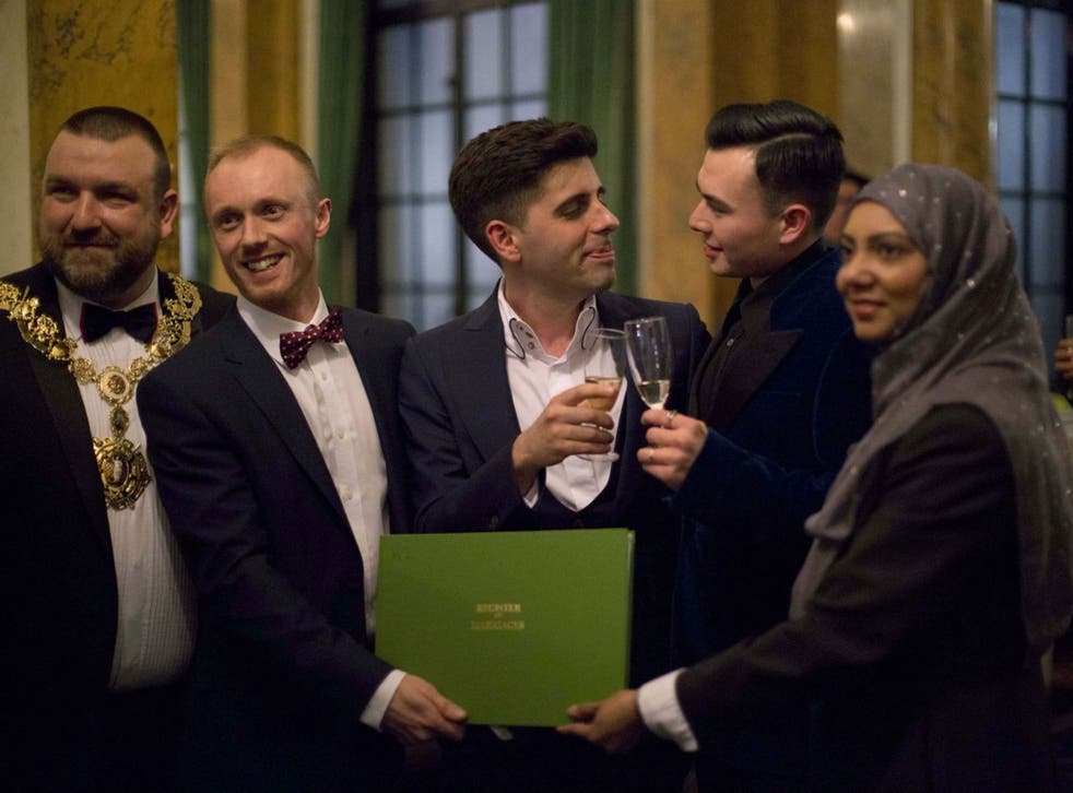 Sean Adl-Tabatabai, third from left, and Sinclair Treadway, fourth from left, pose for photographs with, from left, the openly gay mayor of Camden Jonathan Simpson, deputy superintendent registrar Steven Lord and registrar officer Tania Uddin, after they 
