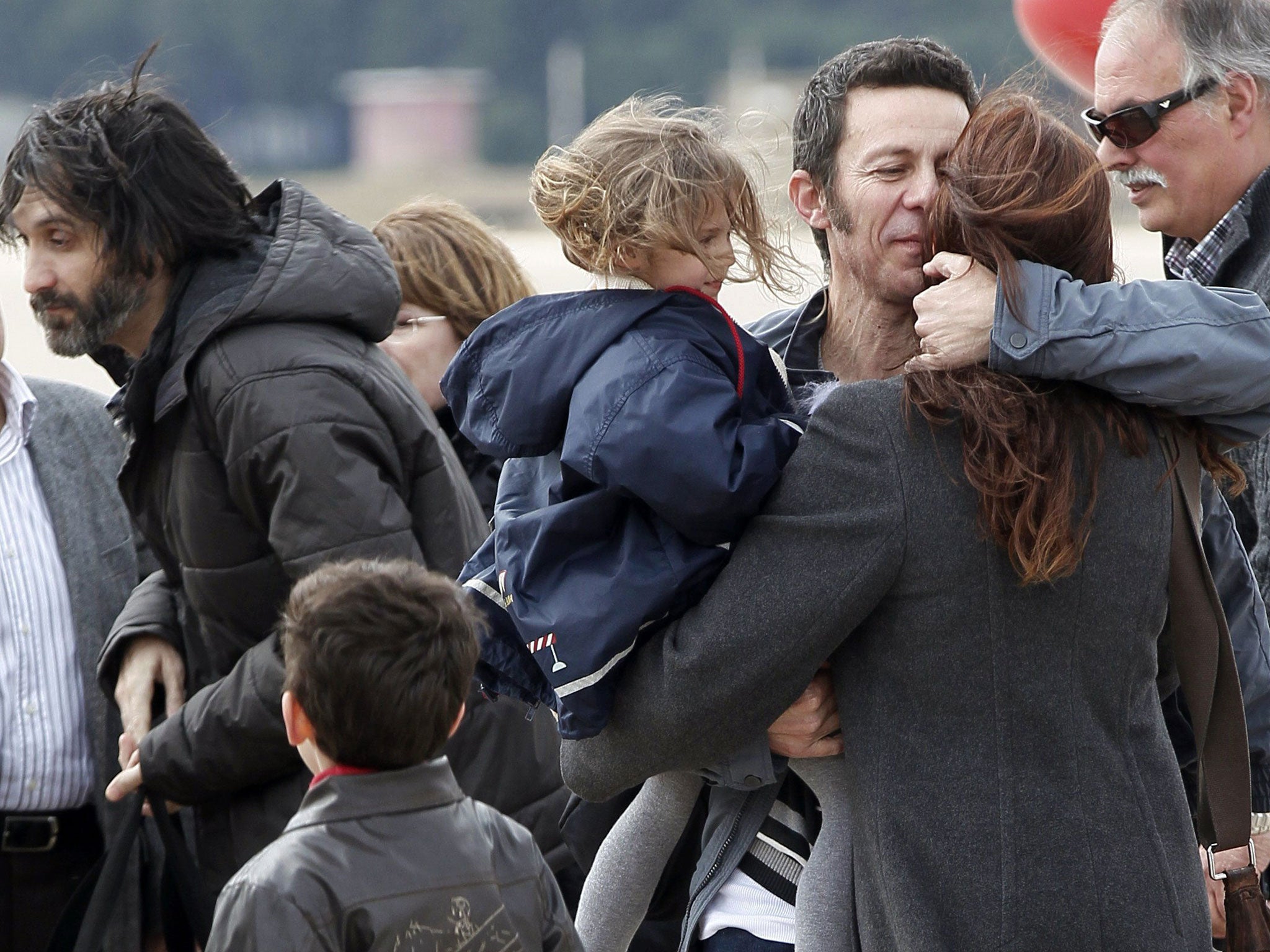 Ricardo García Vilanova, far left, and Javier Espinosa are reunited with their families in Madrid