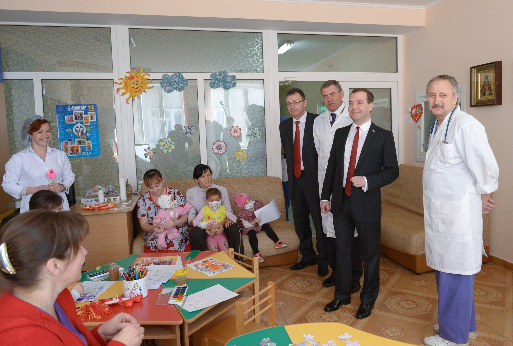 Russian Prime Minister Dmitry Medvedev (2-R) flanked by hospital's chief physician Alexandr Astakhov (3-R) visits the Simferopol Republican Pediatric Hospital in Simferopol, Crimea