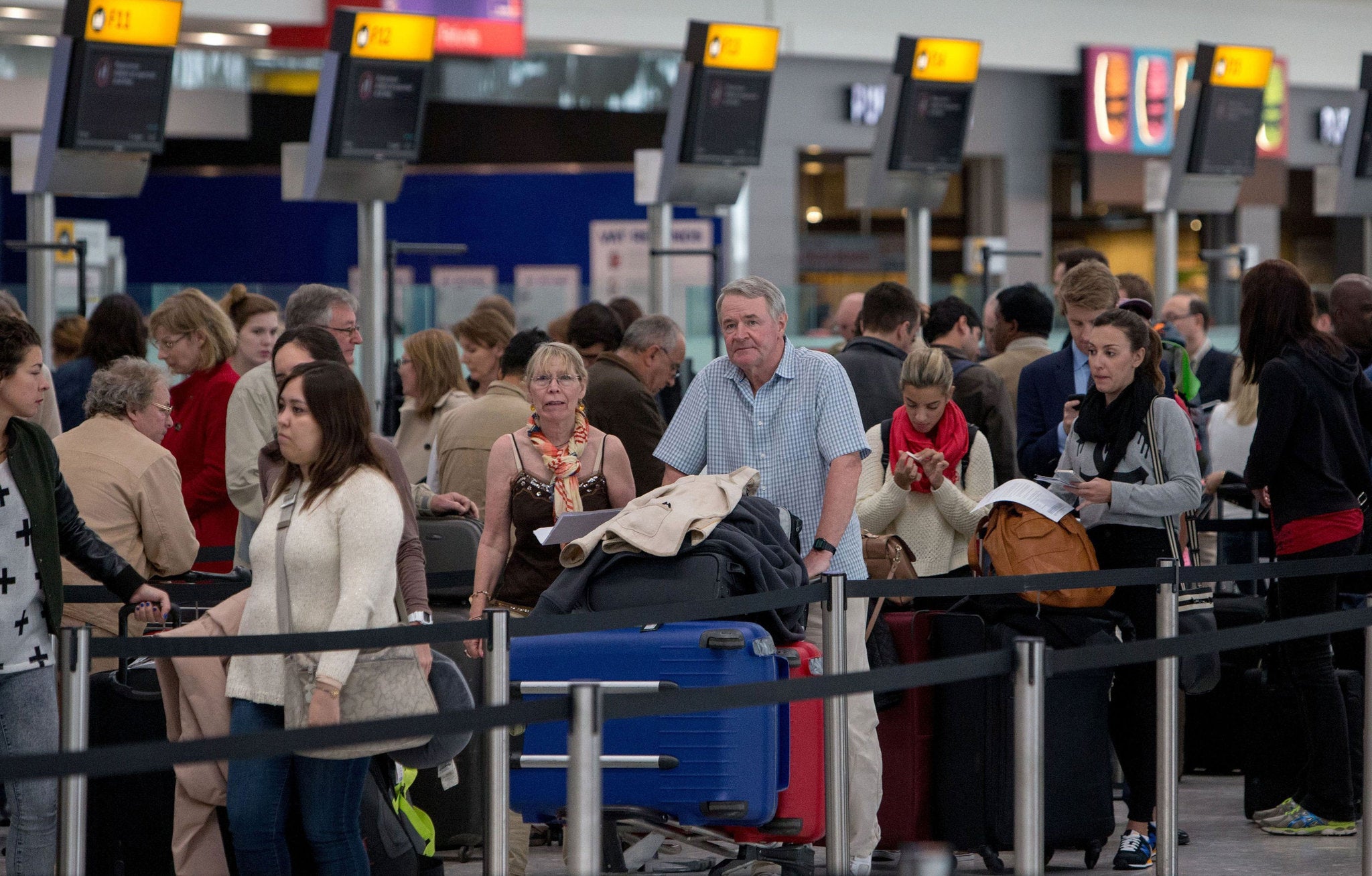 Passengers queue in Terminal 5, Heathrow (PA)