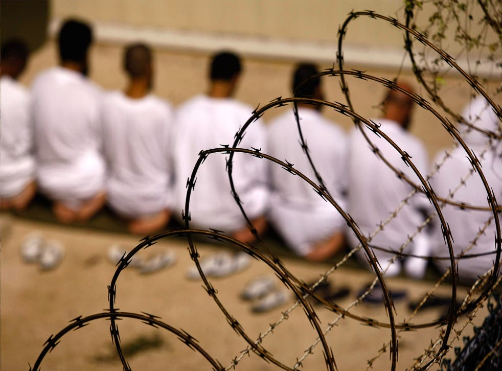 Detainees kneel during an Islamic prayer at Guantanamo Bay, Cuba