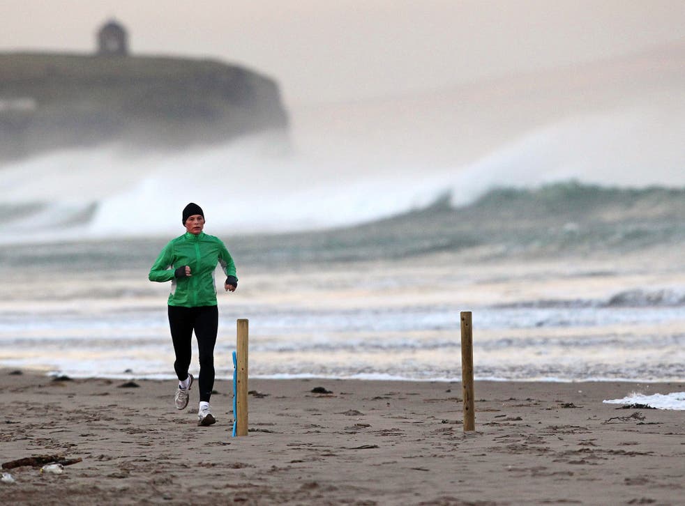 A jogger runs along the shoreline in Portstewart in Northern Ireland