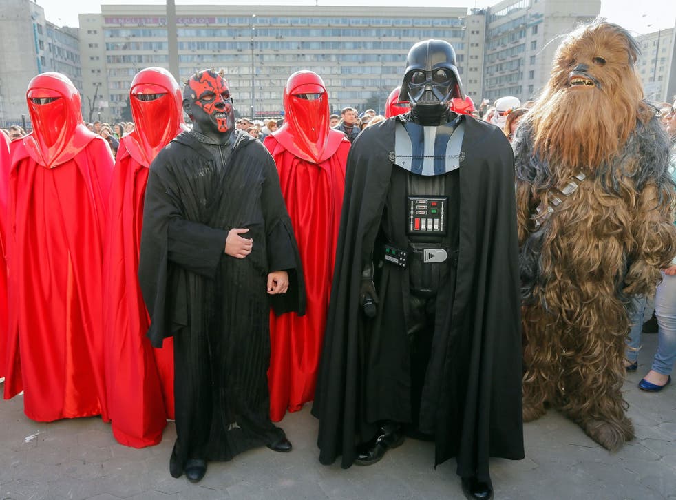A Darth Vader impersonator is accompanied by followers dressed as a Wookie (right), Imperial Guards (in red) and as Sith Lord 'Darth Maul' (centre).