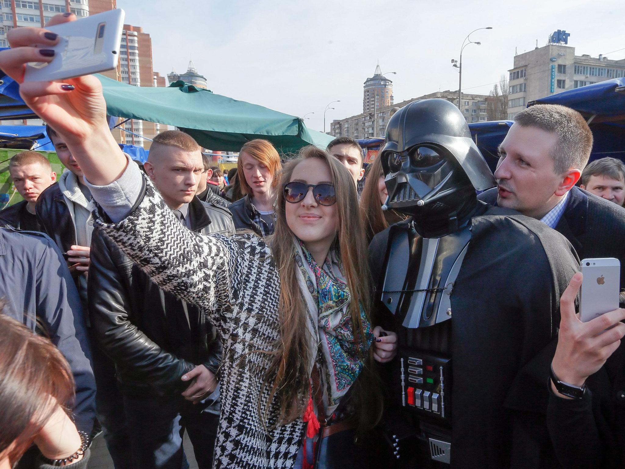 Ukrainians take 'selfie' souvenir snapshots with a 'Darth Vader' impersonator in front of the Central Elections Committee in Kiev