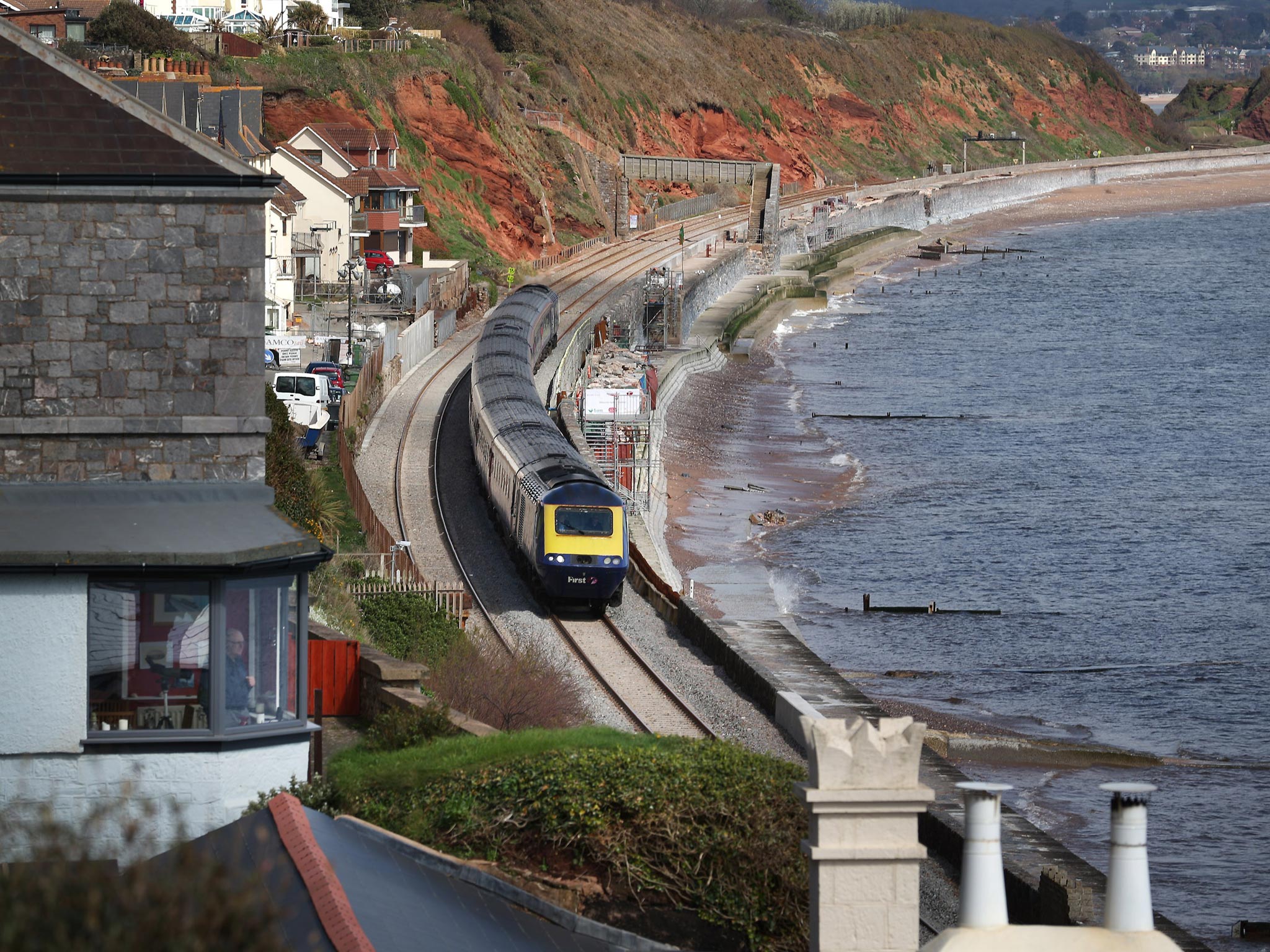 A train passes along the rebuilt track in Dawlish