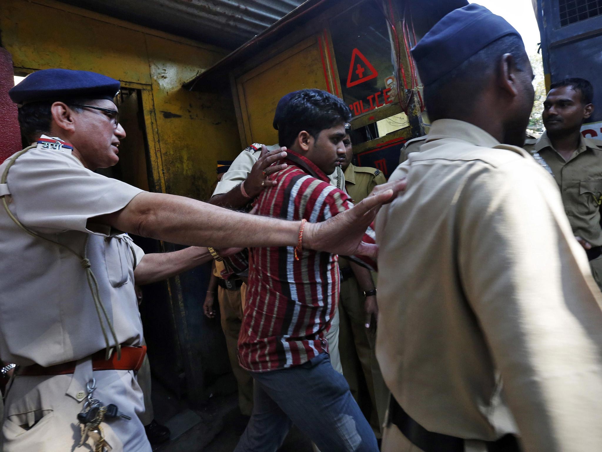 Police escort one of the four men convicted of raping a photojournalist outside a jail in Mumbai