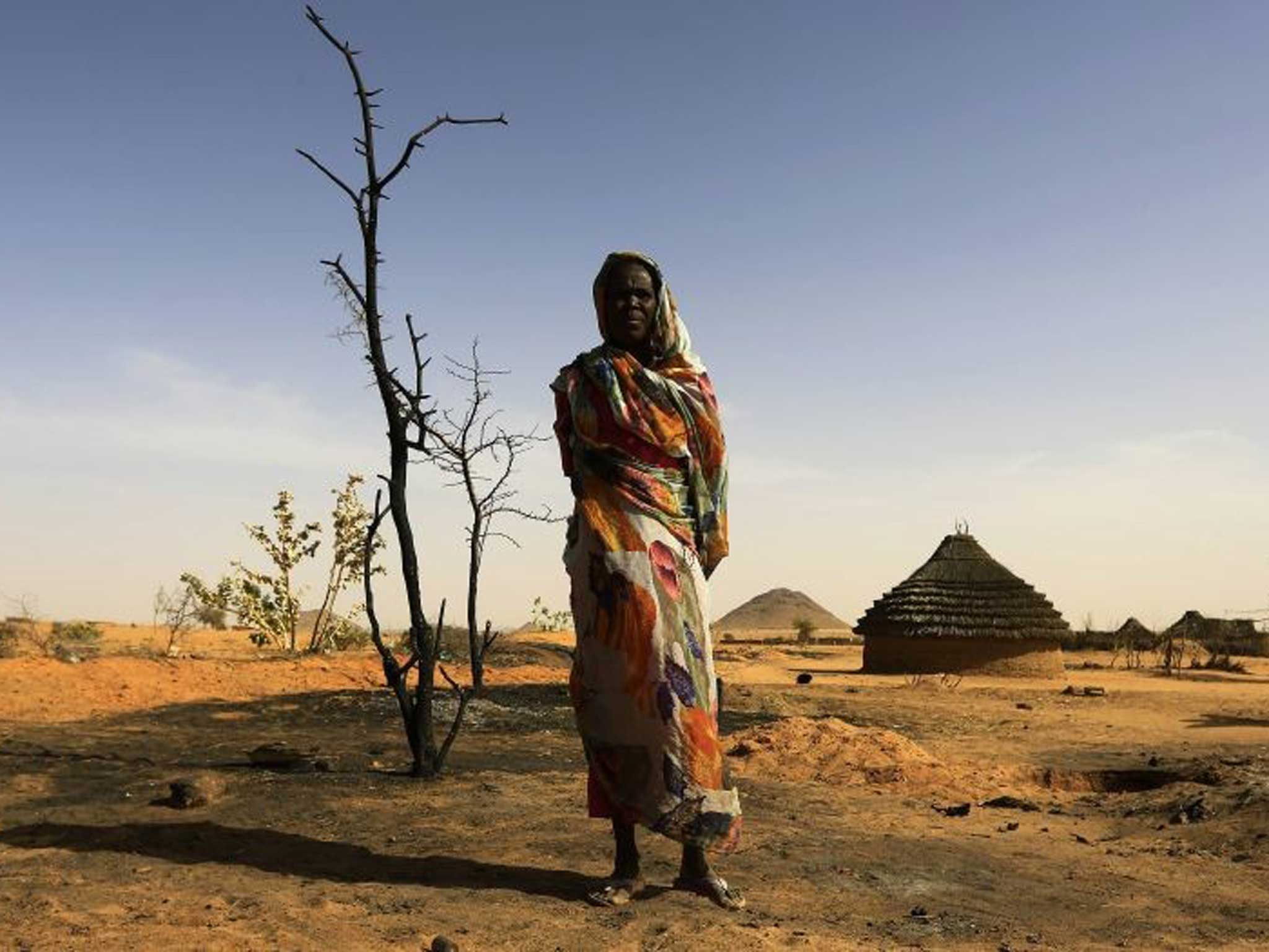 Sudan shame: A woman at what was once her home, burned down by Sudanese rebels