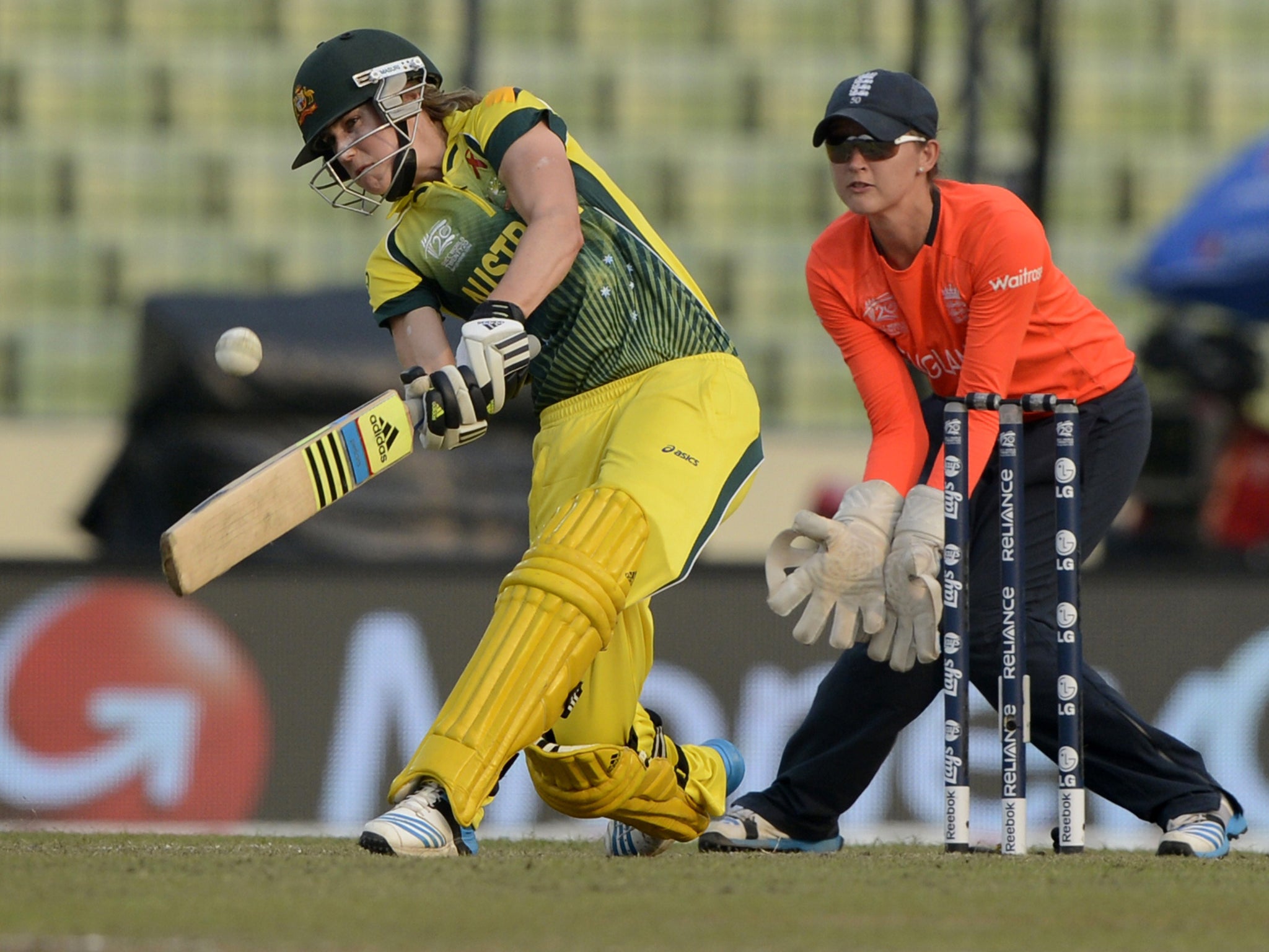 Australian cricketer Ellyse Perry (L) plays a shot as England wicket keeper Sarah Taylor looks on during the ICC Women's World Twenty20 final cricket match