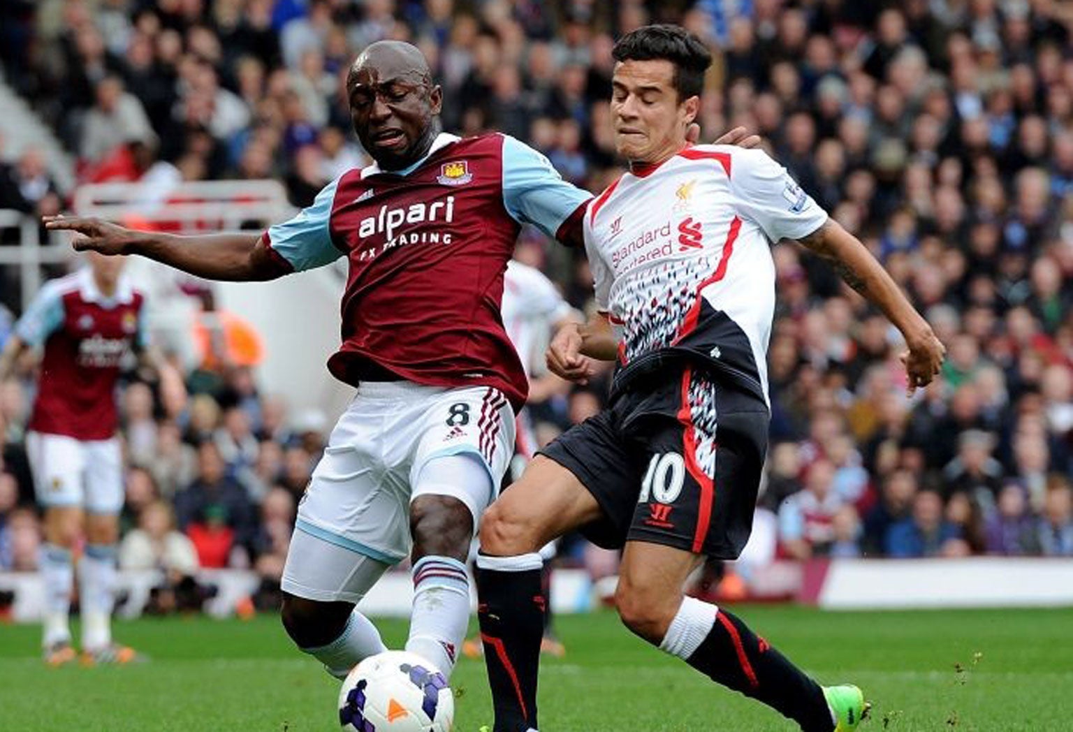 Philippe Coutinho of Liverpool competes with Pablo Armero