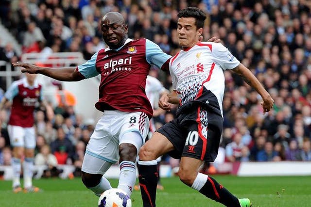 Philippe Coutinho of Liverpool competes with Pablo Armero