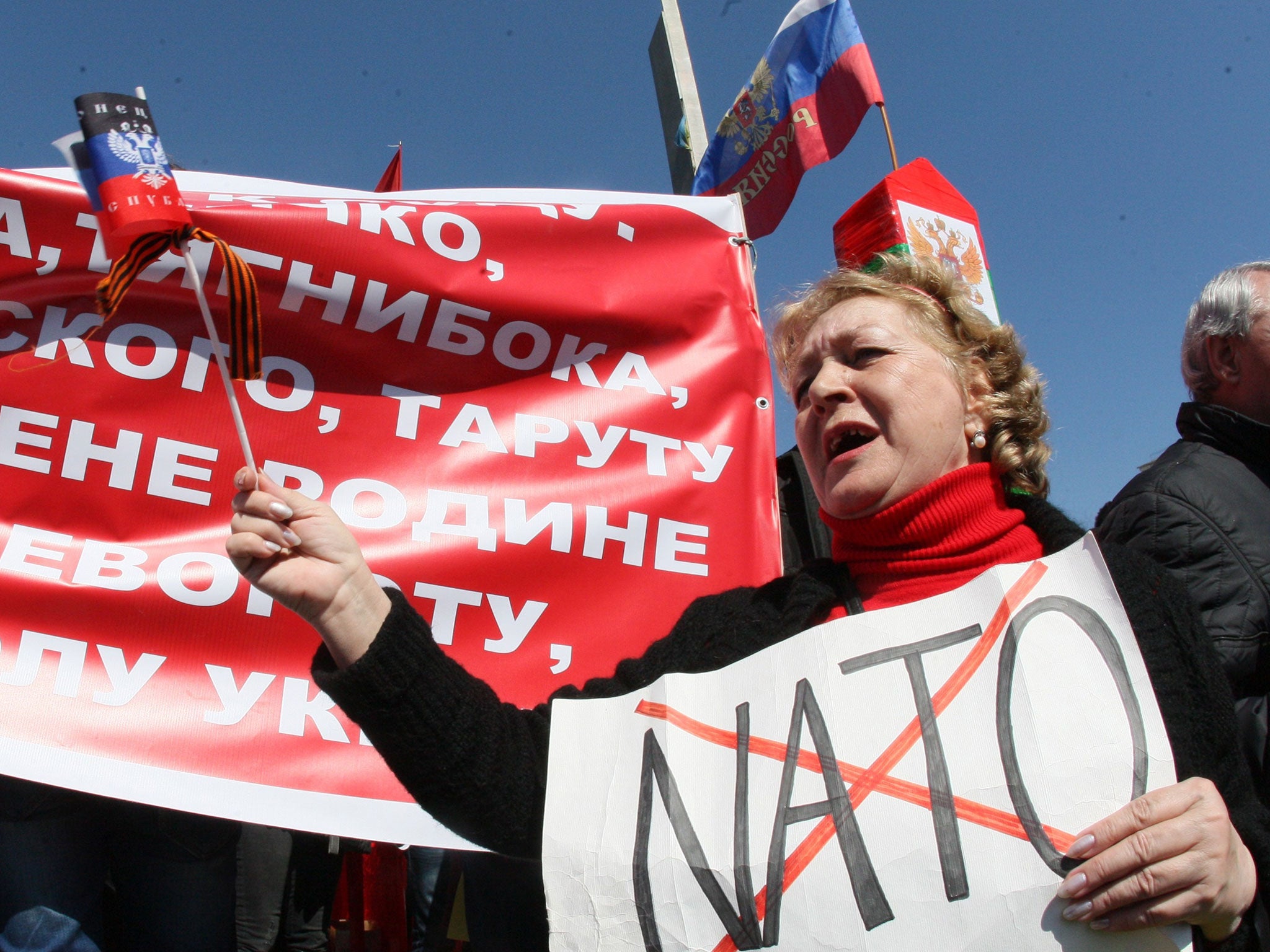 A pro-Russian protester holds a placard bearing a crossed out "Nato" during a rally in the eastern Ukrainian city of Donetsk