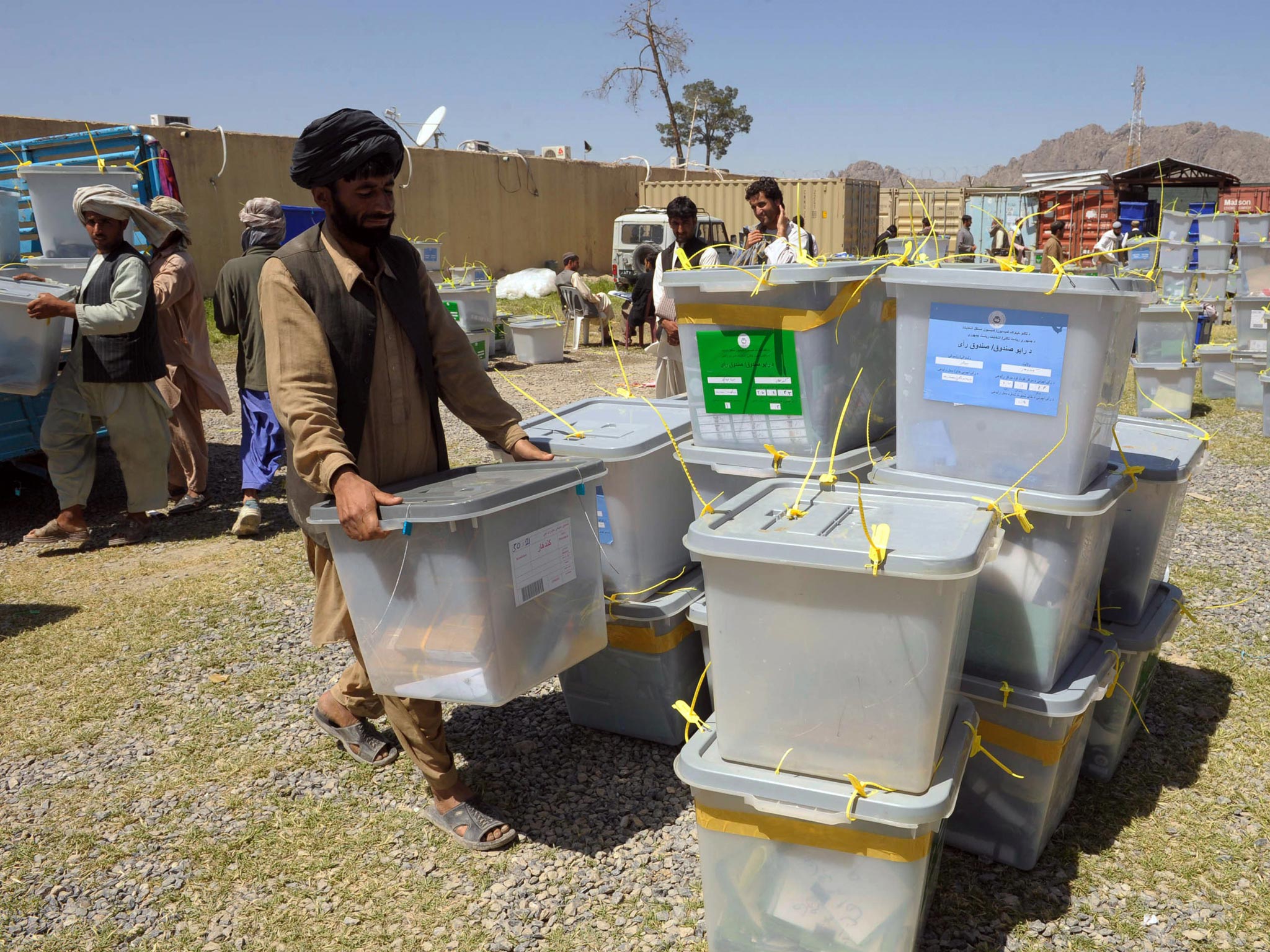 Afghan election commission workers unload ballot boxes at the IEC in Kandahar