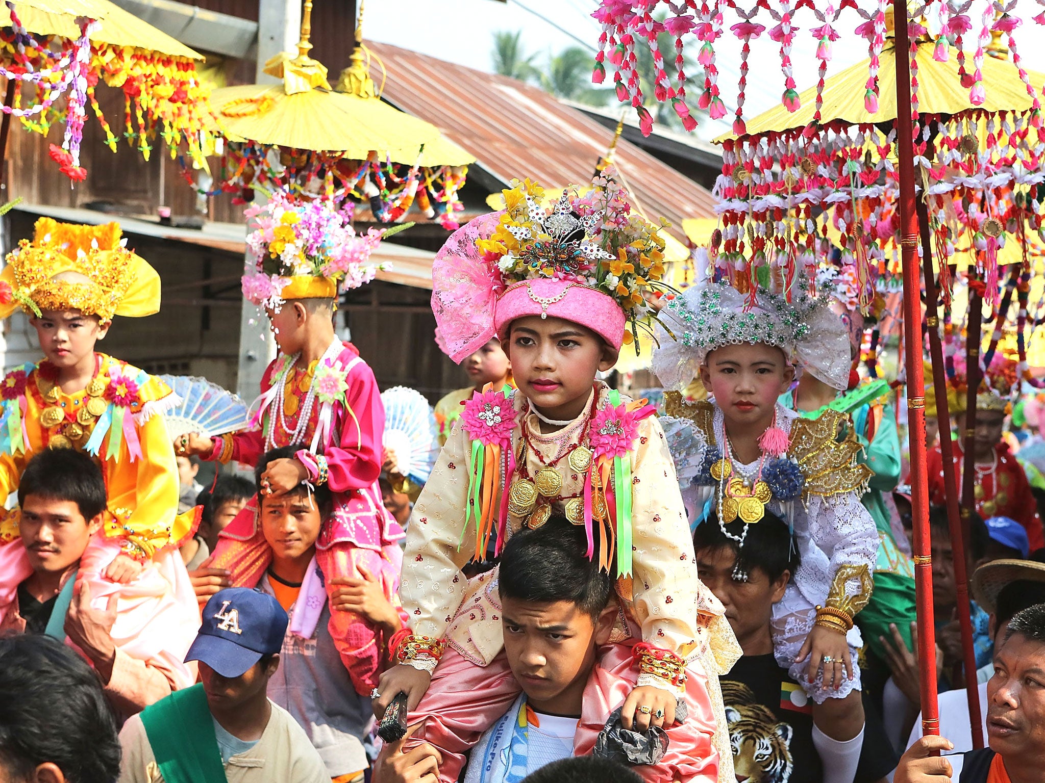 Tai Yai boys are carried in a procession by their relatives during the Poy Sang Long Festival in Mae Hong Son