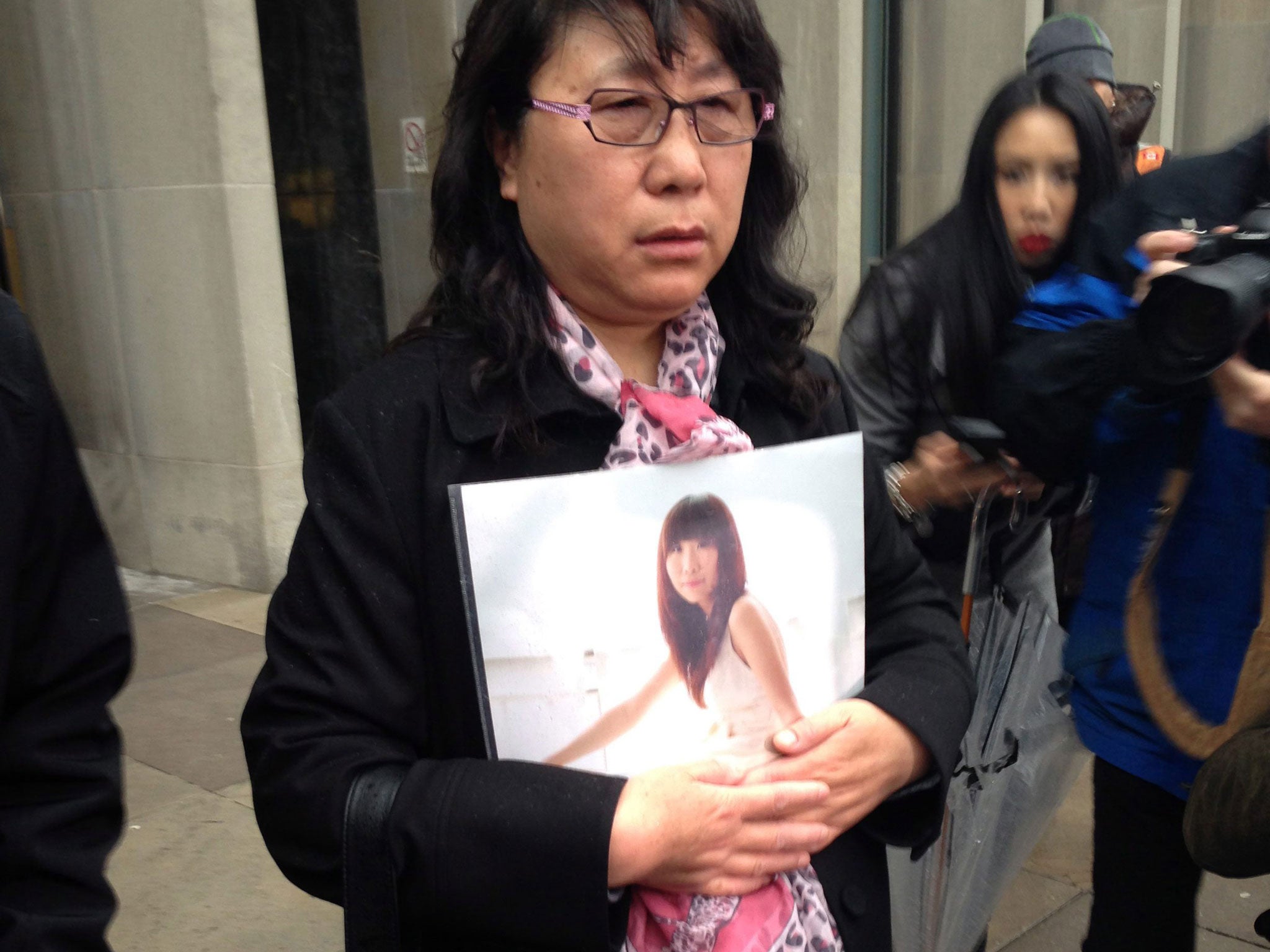 Ya Ru Zheng holds a photo of her daughter Qian Liu outside a courthouse in Toronto