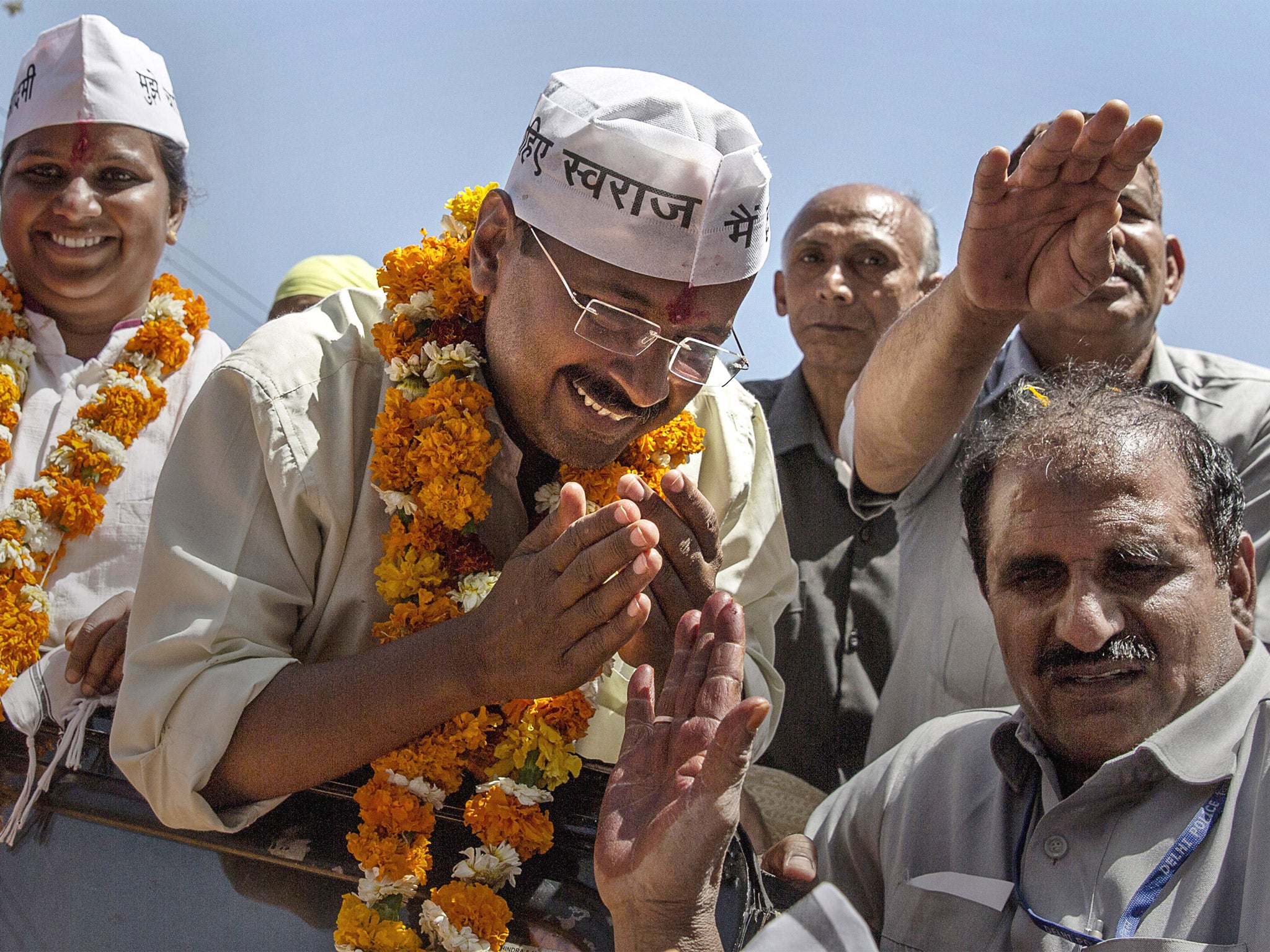 Arvind Kejriwal, centre, greets supporters while campaigning in New Delhi