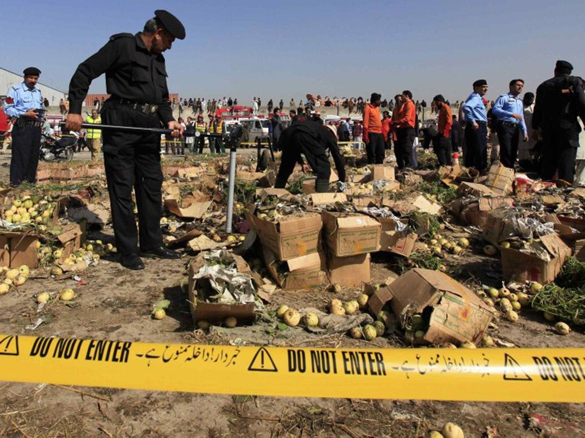 A police official uses a metal detector to search the site of a bomb blast at a vegetable and fruit market in the outskirts of Islamabad on 9 April 2014