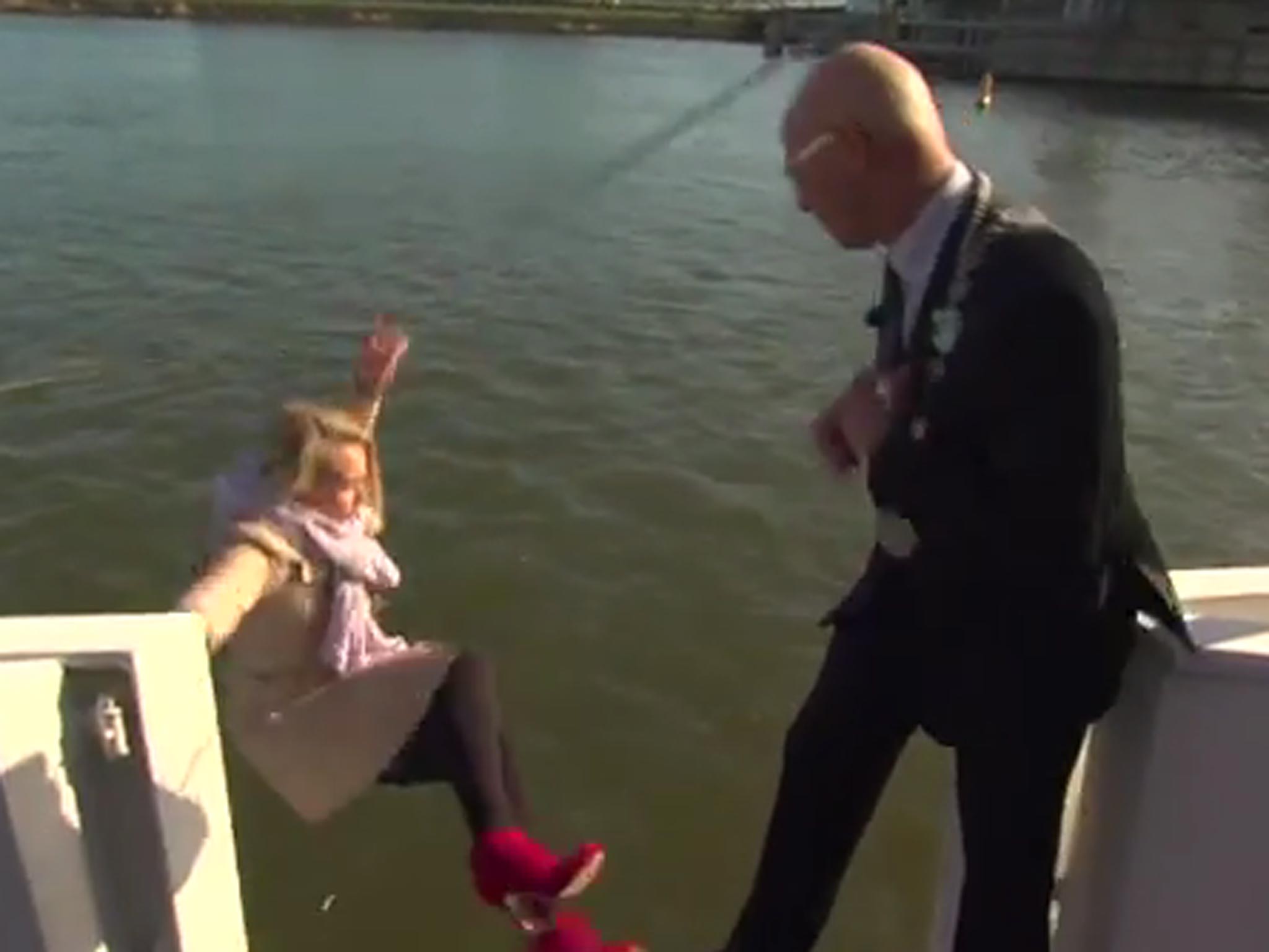 The moment the news reporter tumbles into the water