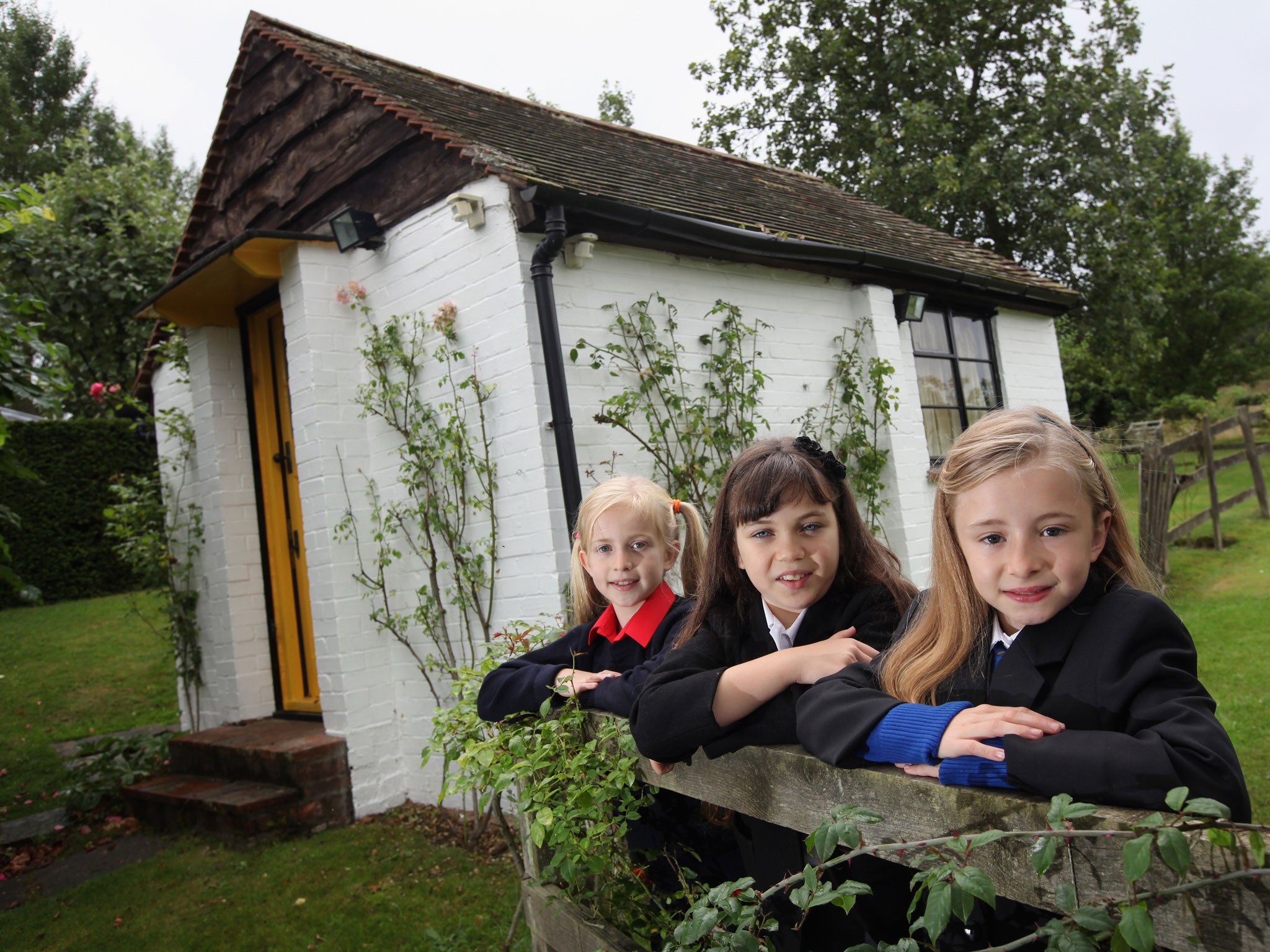 Three school girls cast in the RSC's stage adaptation of Matilda in 2010 stand outside Roald Dahl's writing hut.