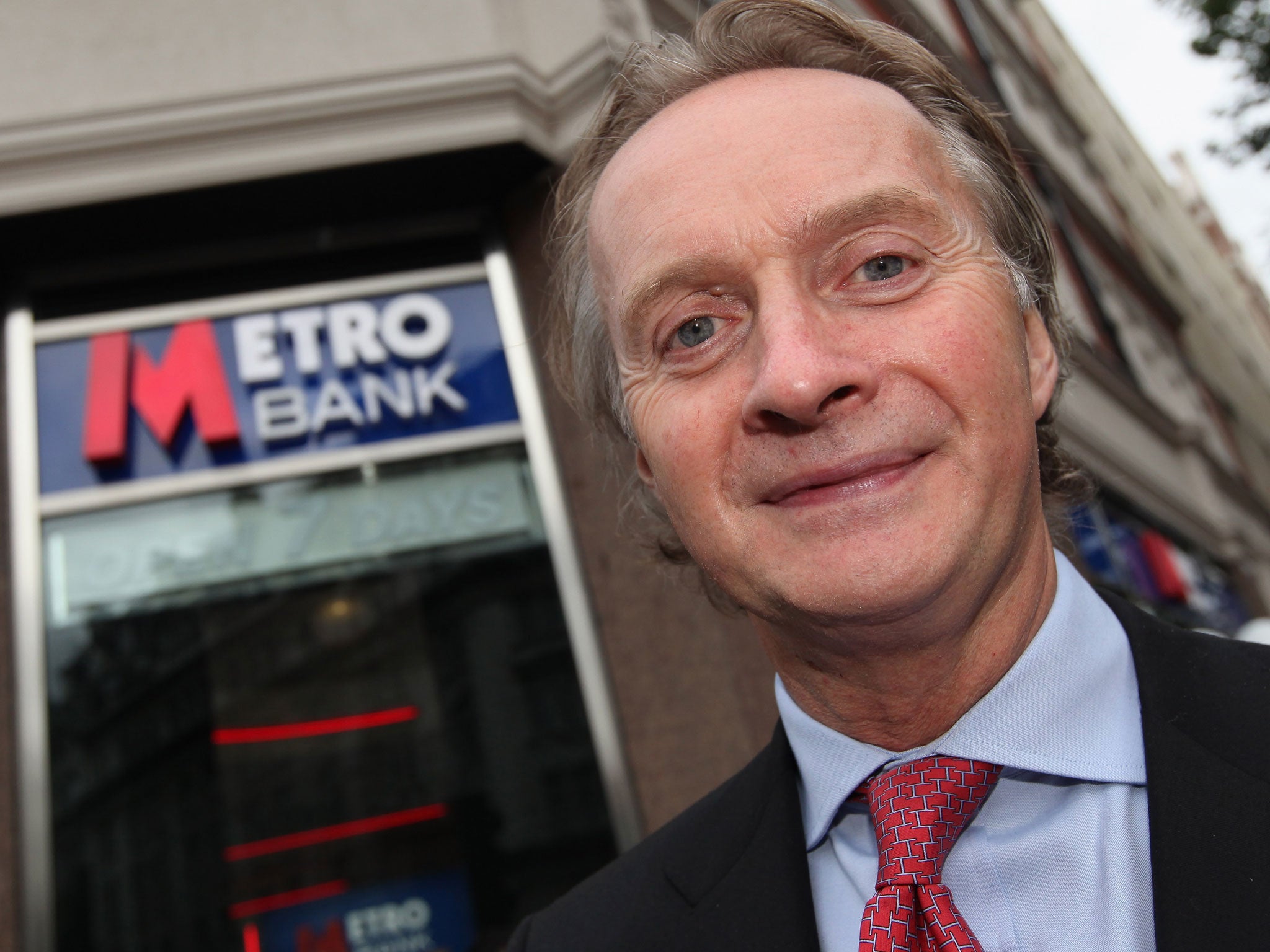 Anthony Thomson poses for a photo outside first branch of Metro Bank as it opens to the public in Holborn on July 29, 2010