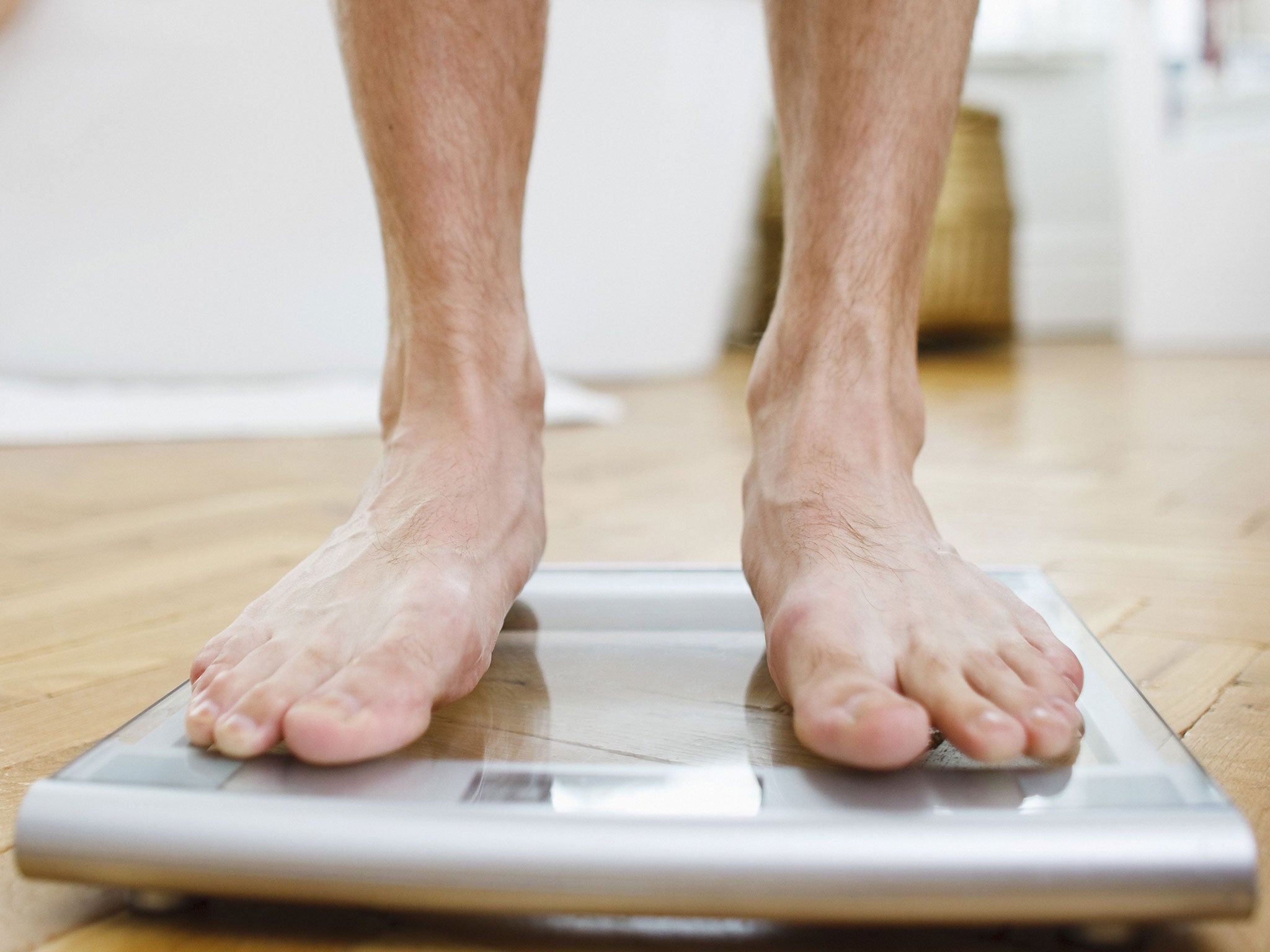 Man weighing himself on bathroom scales
