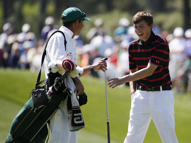 Matthew Fitzpatrick, the English amateur from Sheffield, jokes with his caddie after recovering by the third hole yesterday