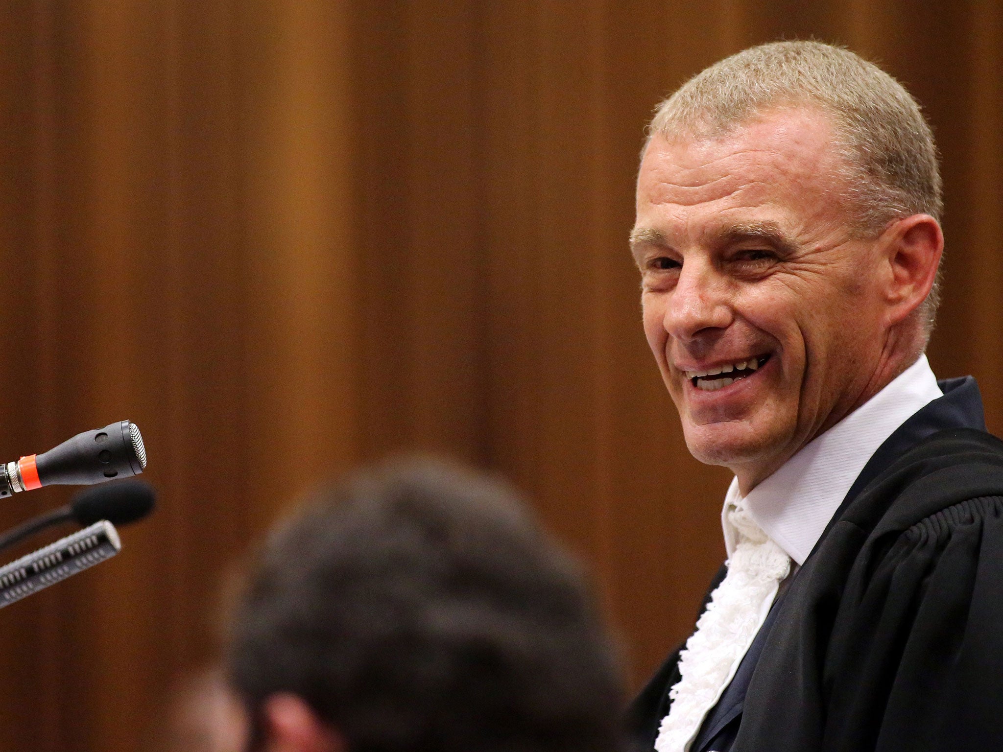 State prosecutor, Gerrie Nel, smiles while cross-examining South African Olympic and Paralympic sprinter Oscar Pistorius during his trial at the North Gauteng High Court
