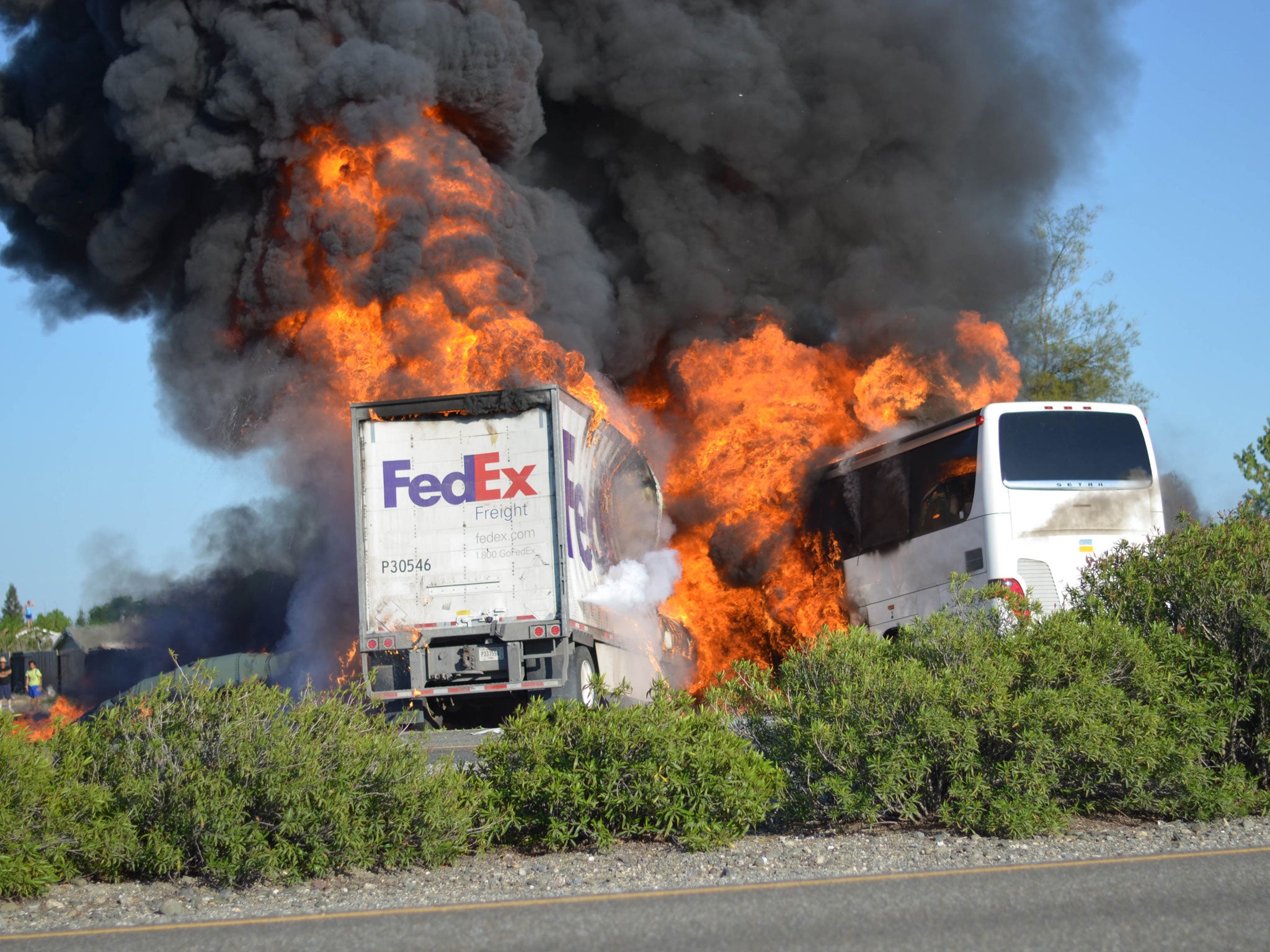 Massive flames engulf a tractor-trailer and a tour bus just after they collide on Interstate 5 near Orland, California