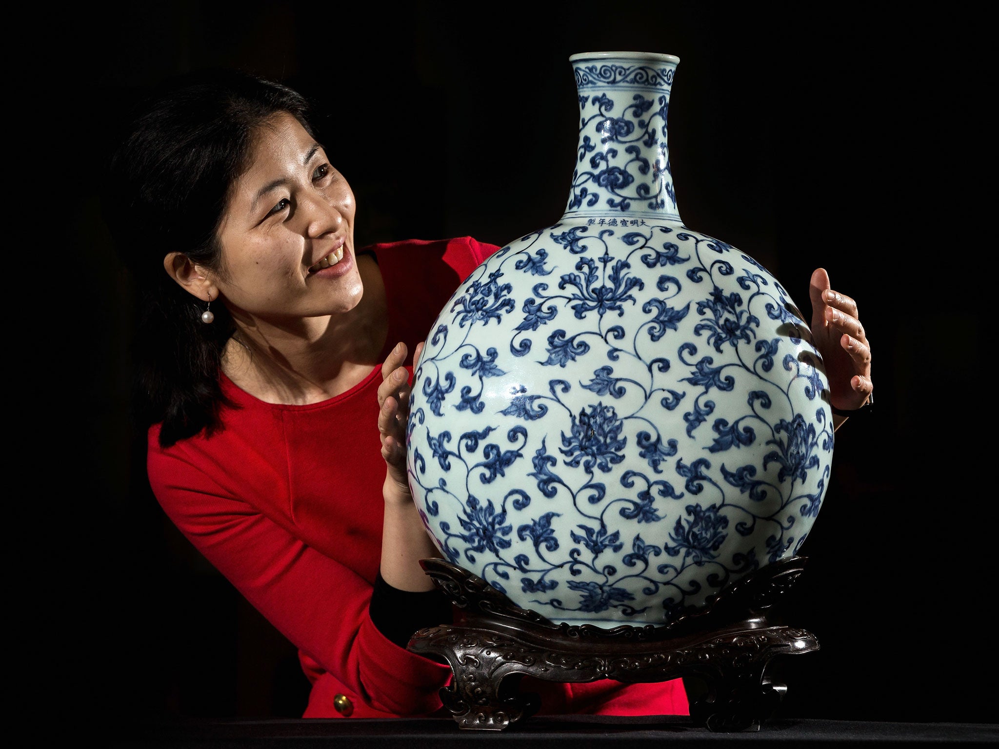 A British Museum employee poses behind a 15th century Imperial Ming Vase.