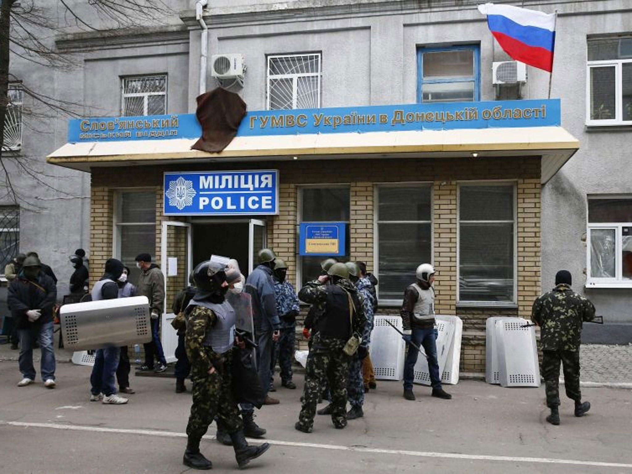 Armed men stand in front of the police headquarters building in Slaviansk, 12 April, 2014.