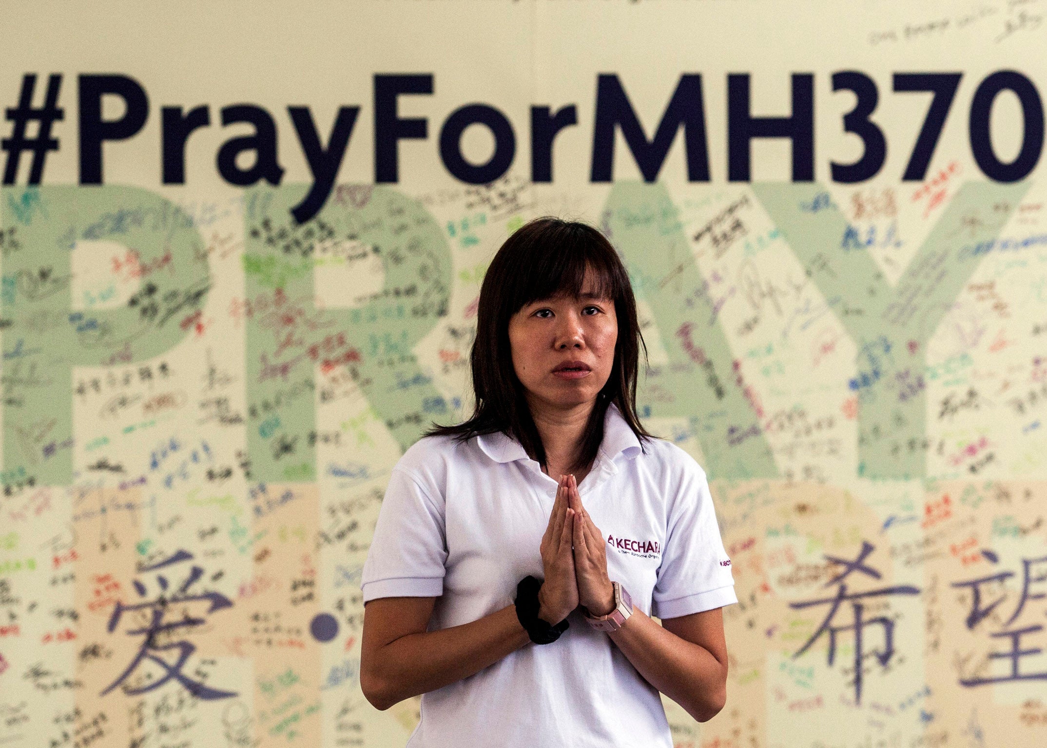 A Buddist devotee offers prayers for the missing Malaysian Airline plane MH370 in Bentong, Pahang, Malaysia