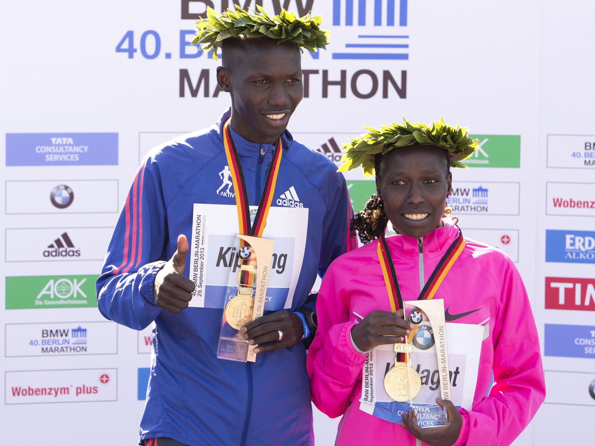 London Marathon winners Wilson Kipsang (left) and Florence Kiplagat (right), both from Kenya, pose on the podium
