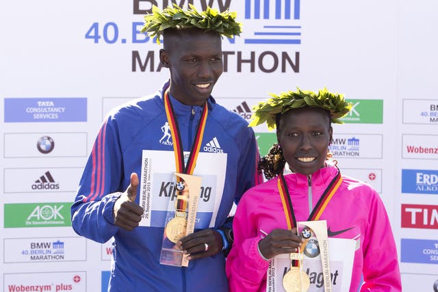 London Marathon winners Wilson Kipsang (left) and Florence Kiplagat (right), both from Kenya, pose on the podium 
