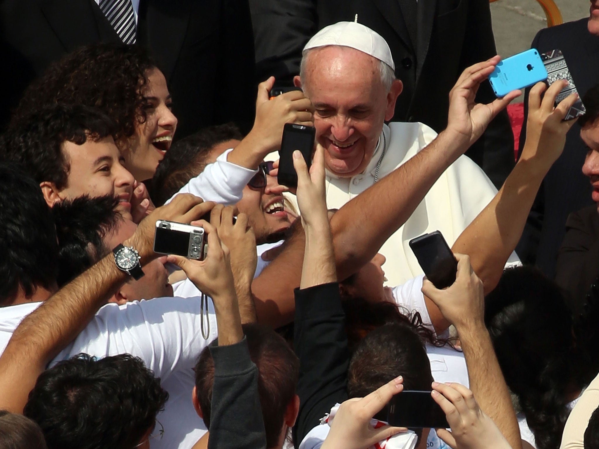 Pope Francis poses to take selfies with Brazilian boys as he attends Palm Sunday Mass at St Peter's Square 13 April, 2014