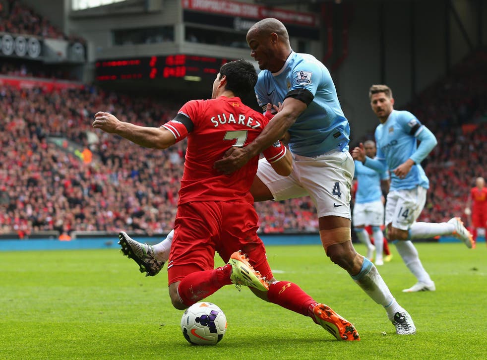 Luis Suarez collides with Vincent Kompany in the area during the 3-2 win for Liverpool over Manchester City