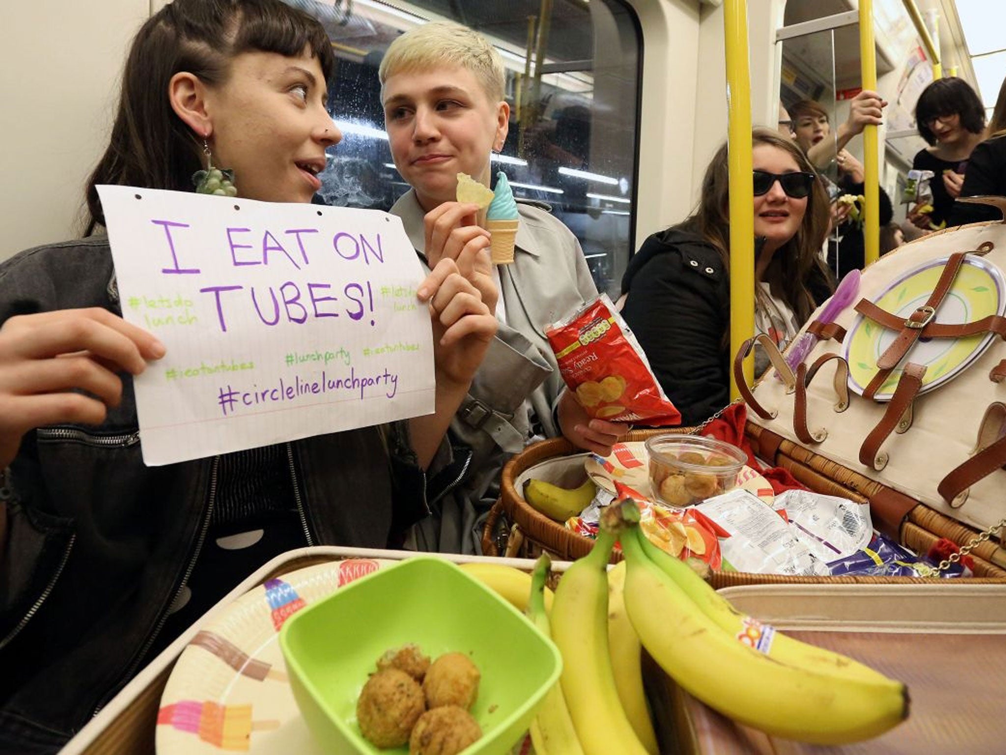 Alexis Calvas (left) and Lucy Brisbane McKay (right), organisers of a 'Lunch Party' on the circle line underground tube in London, 14 April 2014.