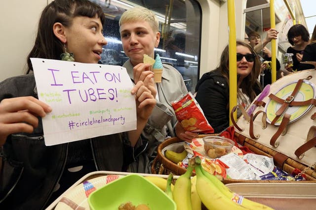 Alexis Calvas (left) and Lucy Brisbane McKay (right), organisers of a 'Lunch Party' on the circle line underground tube in London, 14 April 2014. 