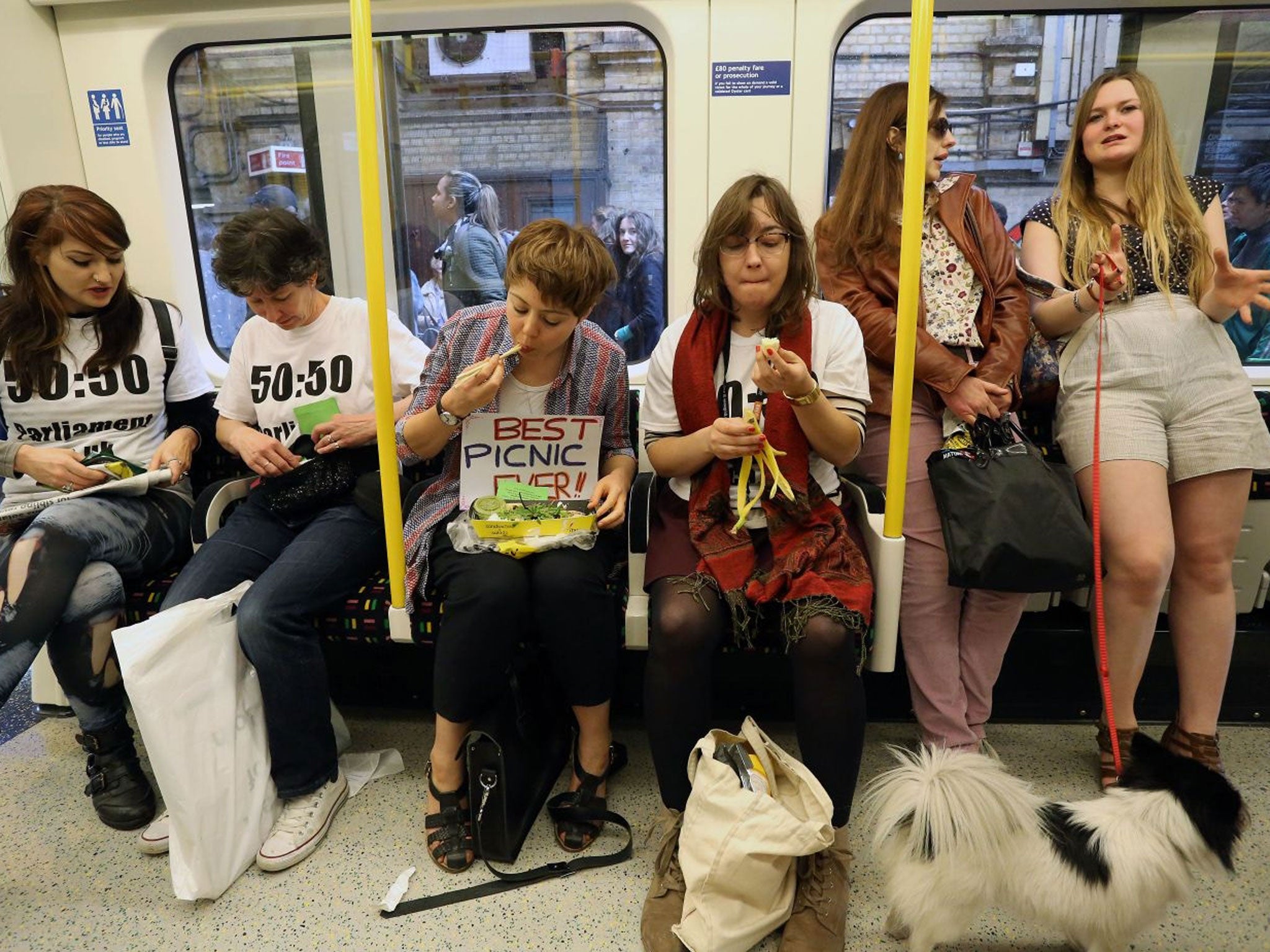 Women taking part in a 'Lunch Party' on the circle line underground tube in London, April 14th, 2014. The event was organised as a counter-offensive against the Facebook website 'Women Who Eat on Tubes'.