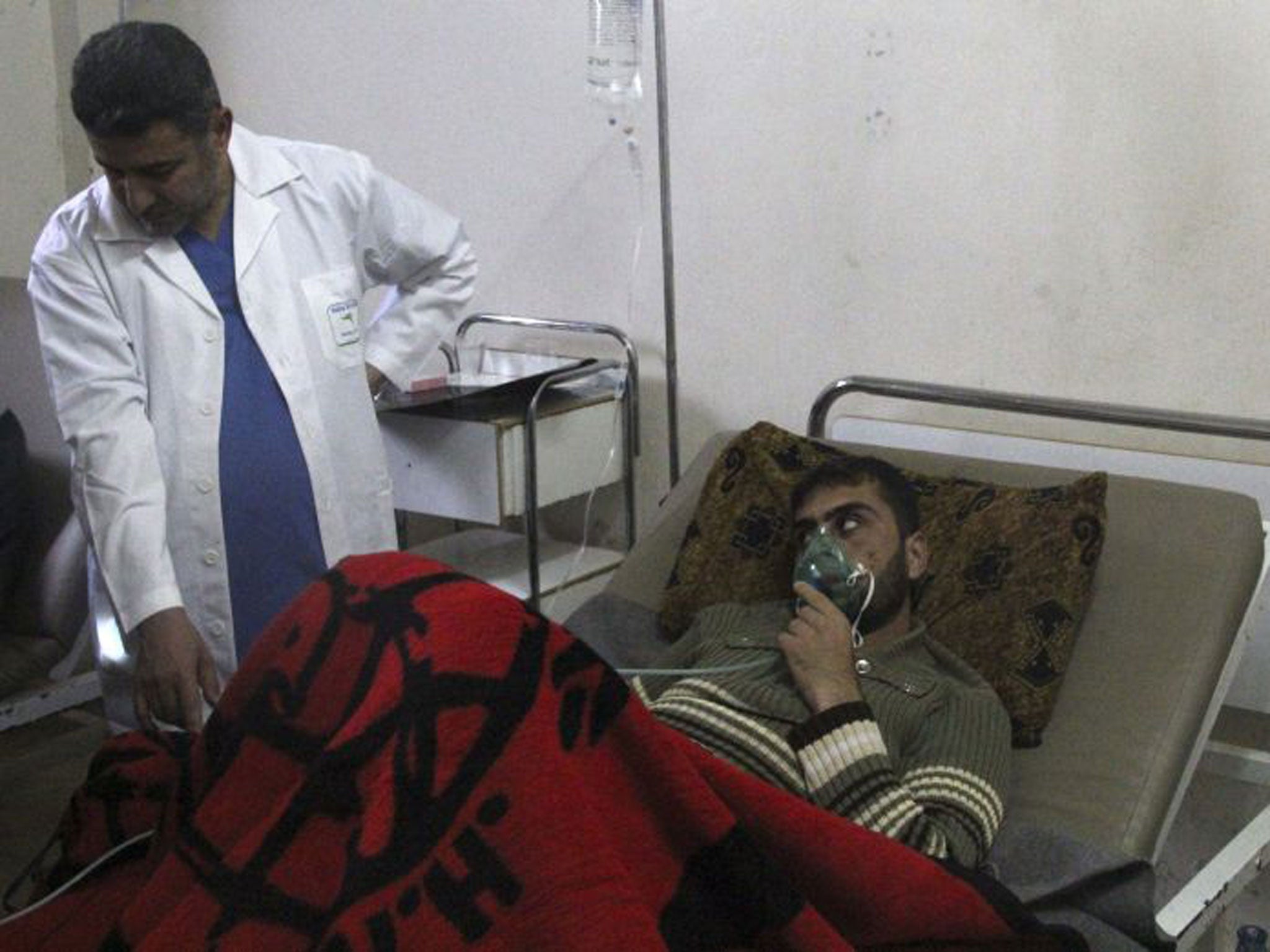 A man, apparently affected by a gas attack, breathes through an oxygen mask in Kfar Zeita village
